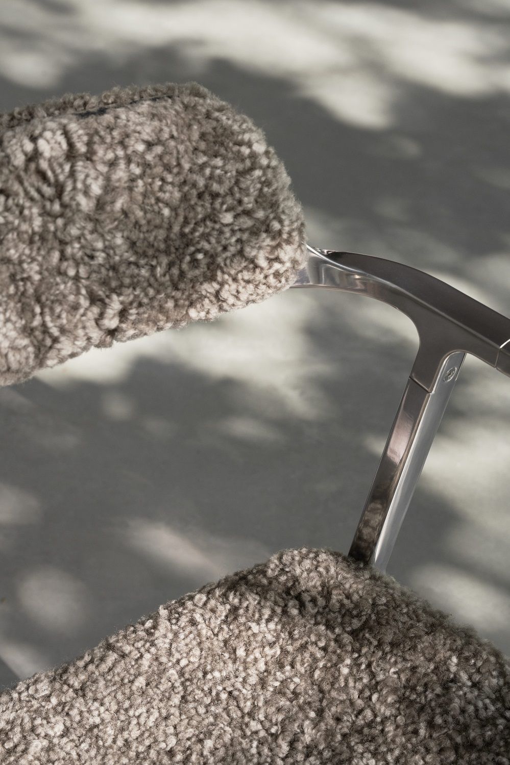 Detailaufnahme des Vipp Curly Stuhls SPECIAL EDITION mit grauem, lockigem Stoffbezug und silbernem Gestell.