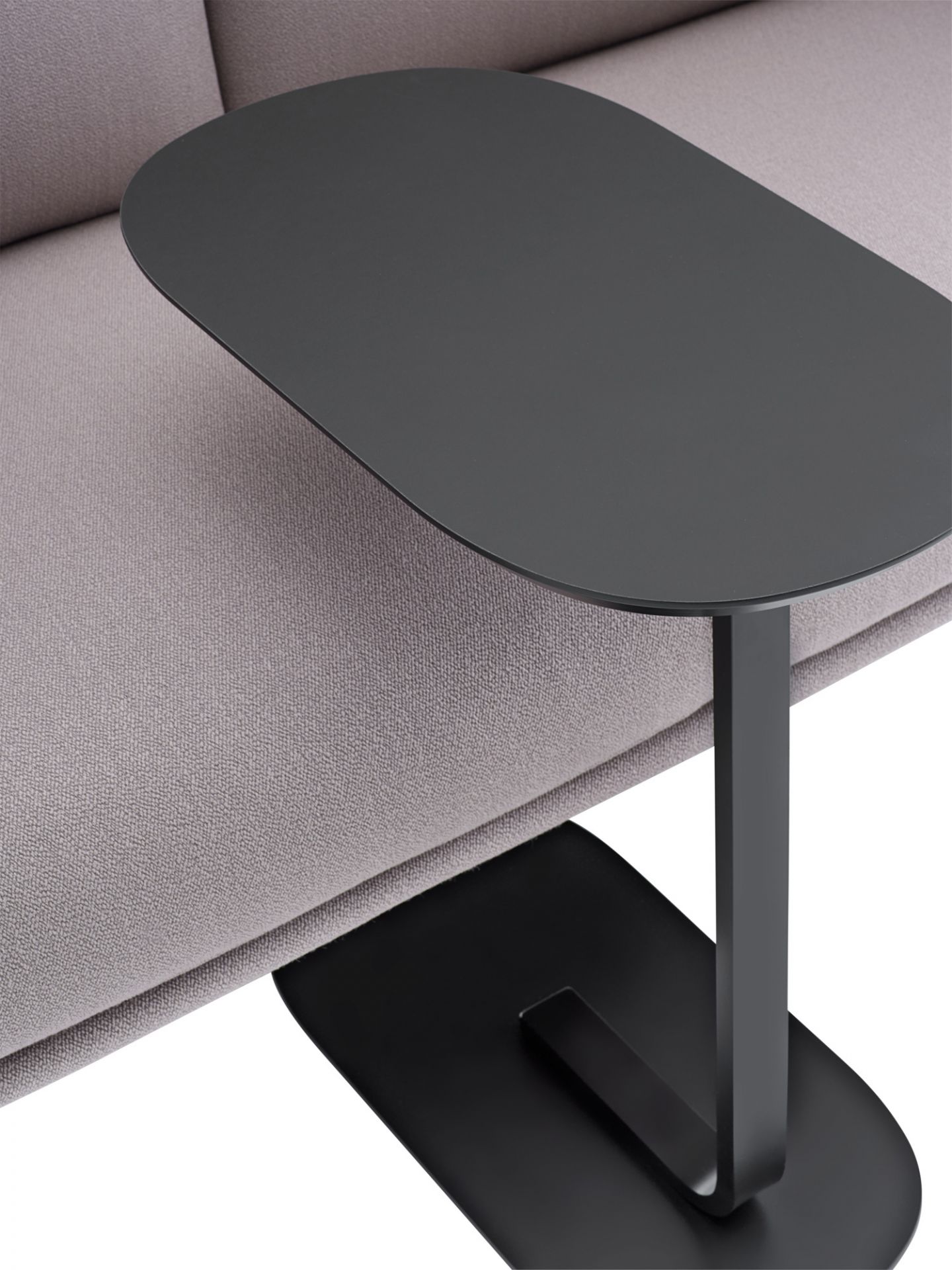 Schwarzer Relate Beistelltisch von Muuto, niedrige Ausführung, neben einem Sofa platziert. Modernes Möbeldesign.