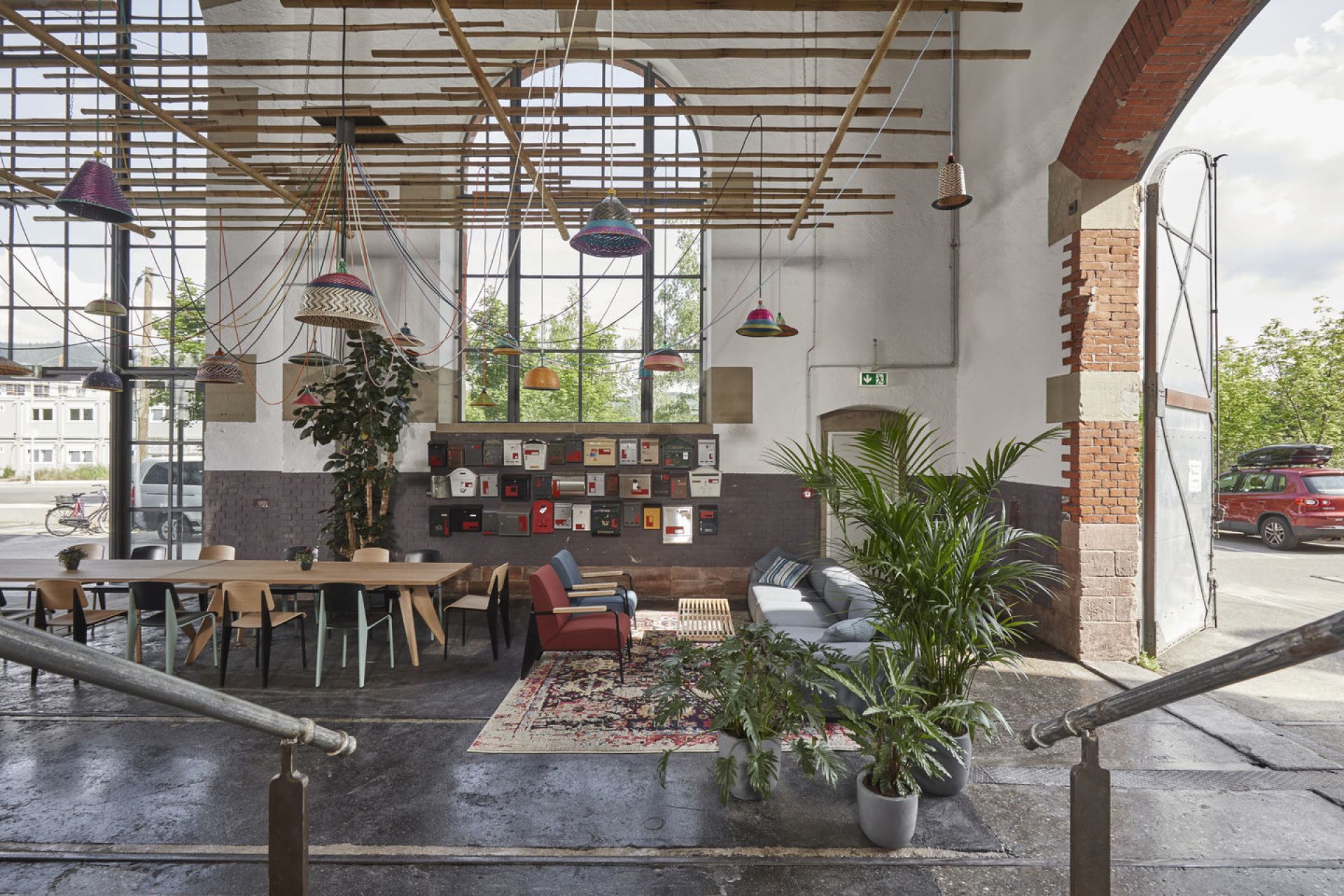 Innenaufnahme mit Vitra Fauteuil Direction Sessel in rotem Stoffbezug, Teil einer Büroeinrichtung im Loftstil.