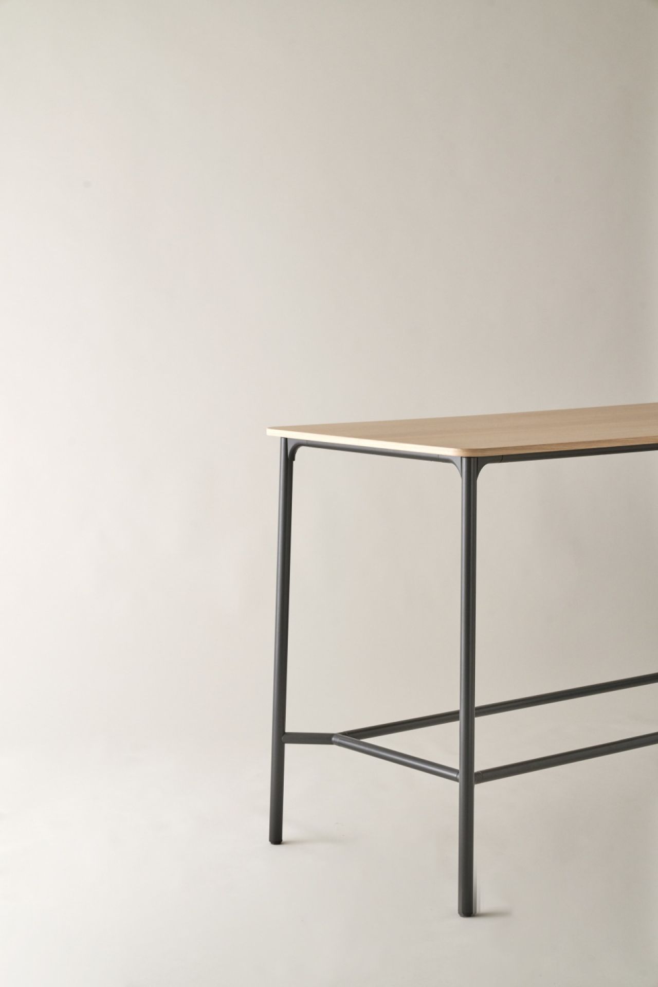 Nate S Stehtisch von Brunner mit heller Holzplatte und schwarzem Metallgestell.