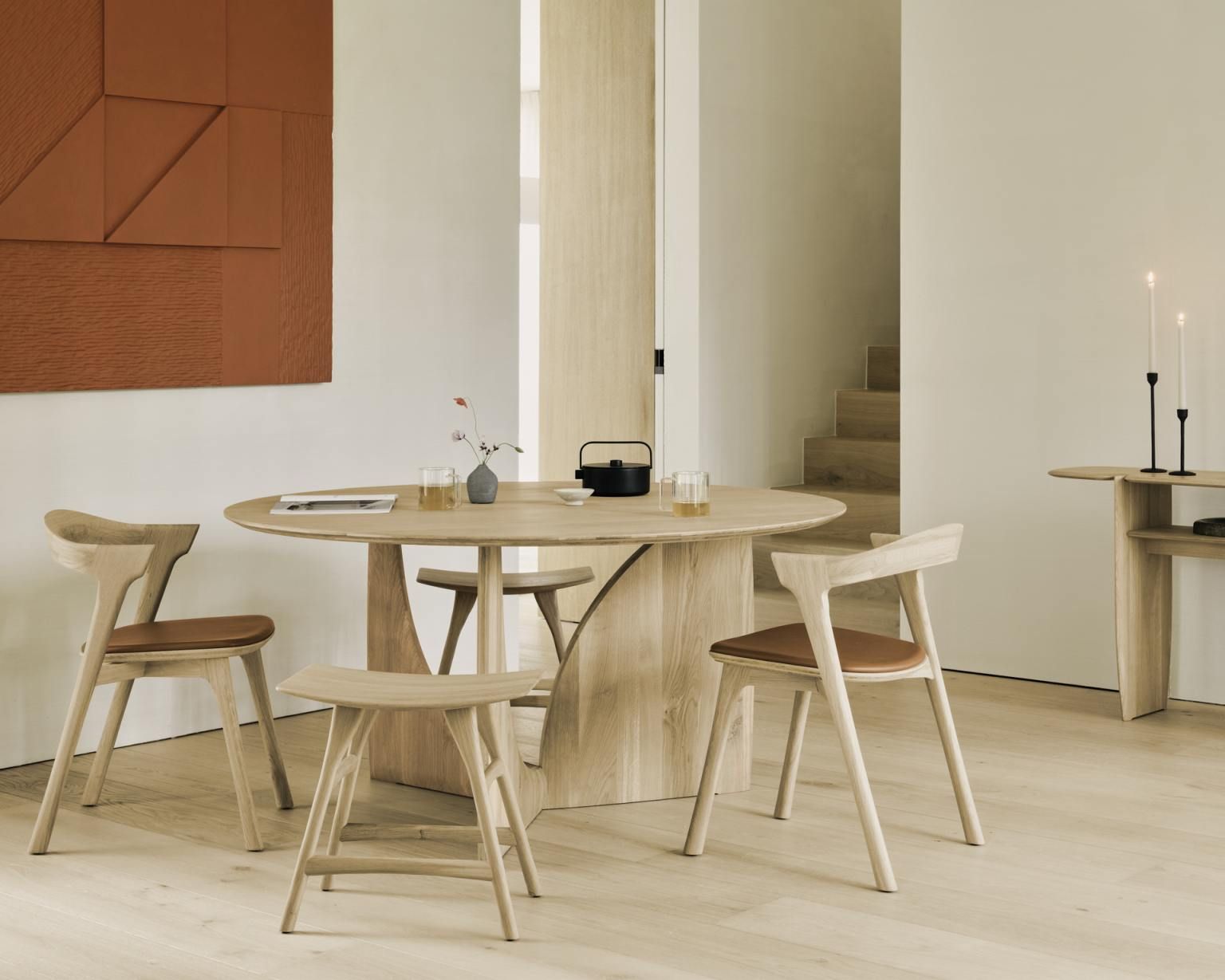 Ethnicraft Geometric Dining Table: Runder Esstisch aus hellem Holz mit passenden Stühlen im Esszimmer.