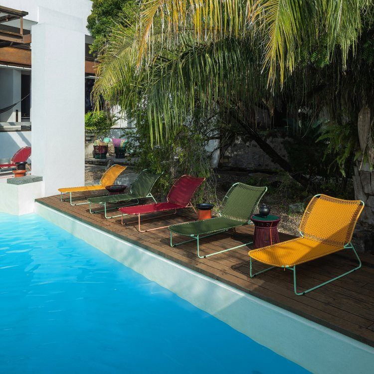Mehrere Cielo Daybeds von ames in Rot, Gelb und Grün am Pool. Outdoor Liege.