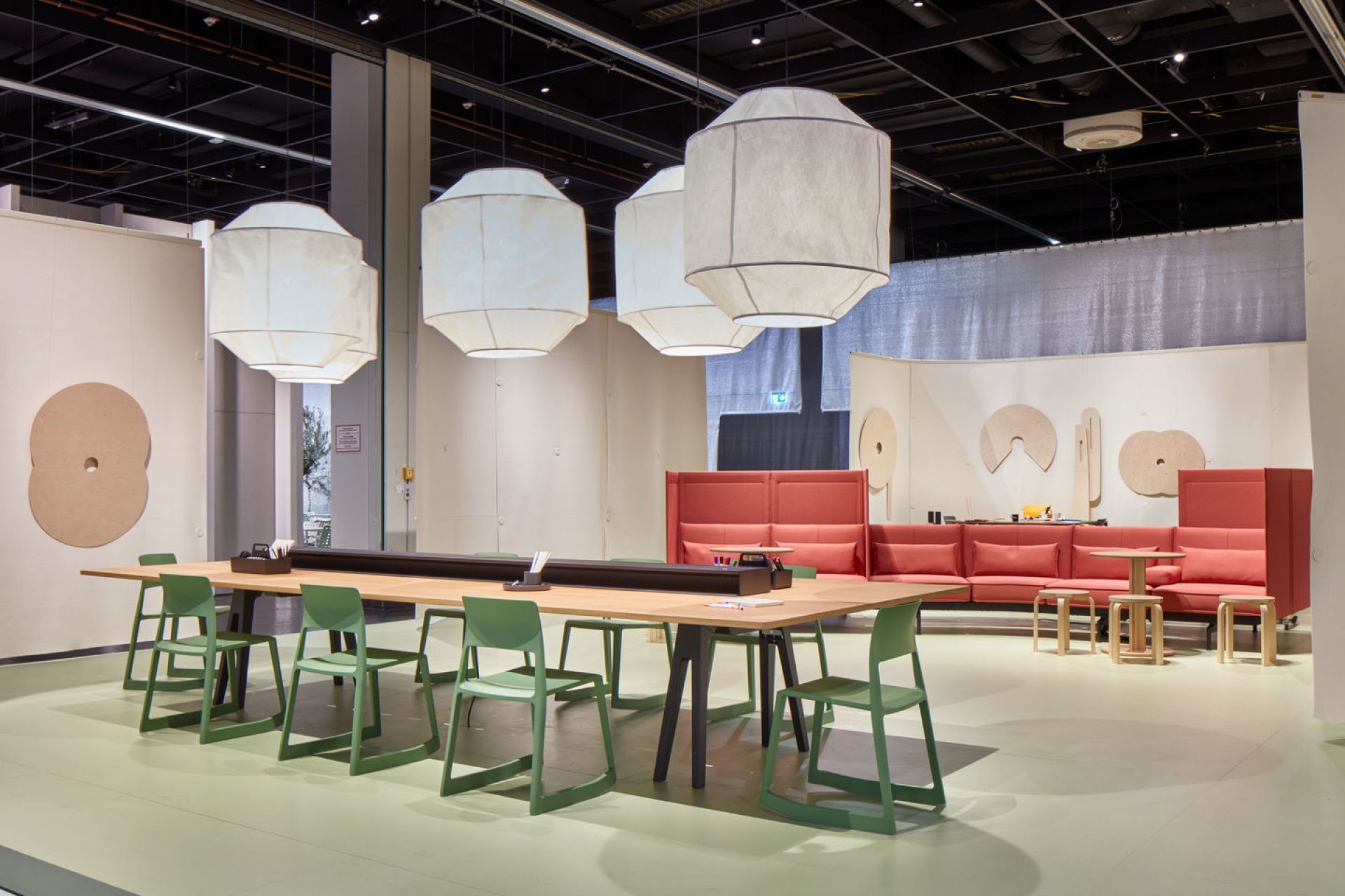 Grüne Tip Ton RE Stühle von Vitra um einen Holztisch in einem modernen Büro.