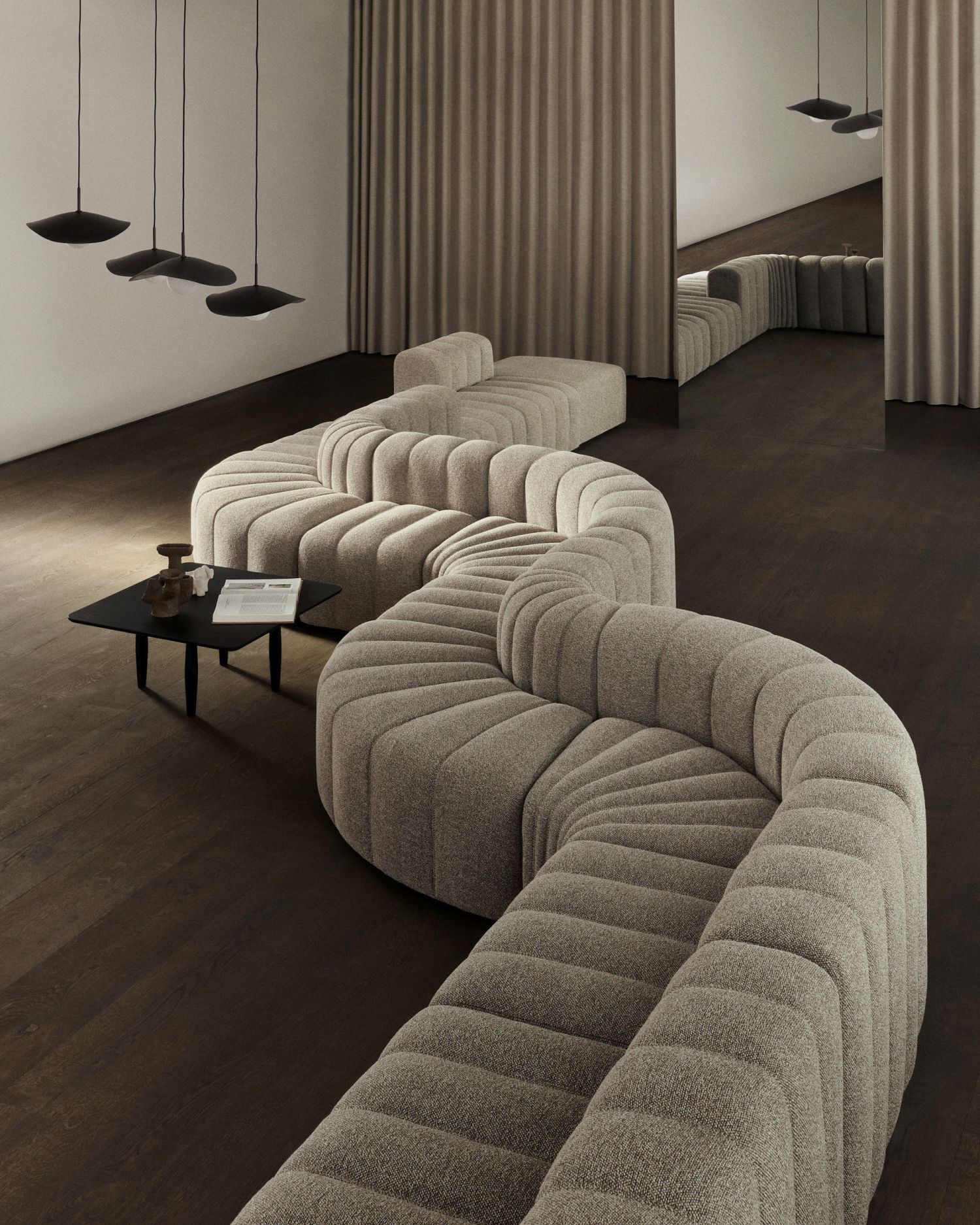 Moderne Wohnzimmergestaltung mit geschwungener Couch, schwarzem Couchtisch und Fuji Pendelleuchten von Norr11 für stilvolle Beleuchtung.