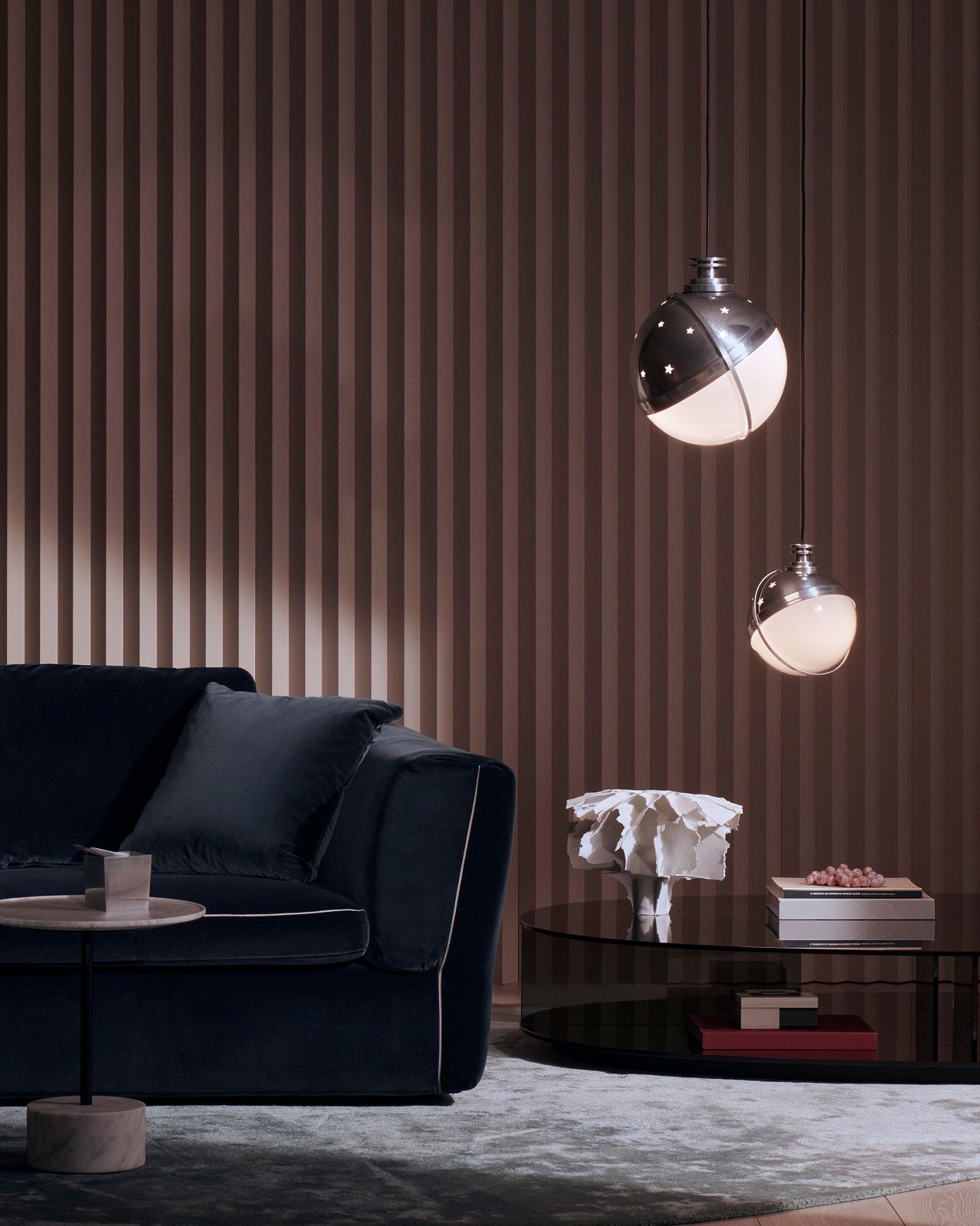 Zwei Helena Pendelleuchten aus Aluminium von Cassina über einem Wohnzimmer mit Sofa.