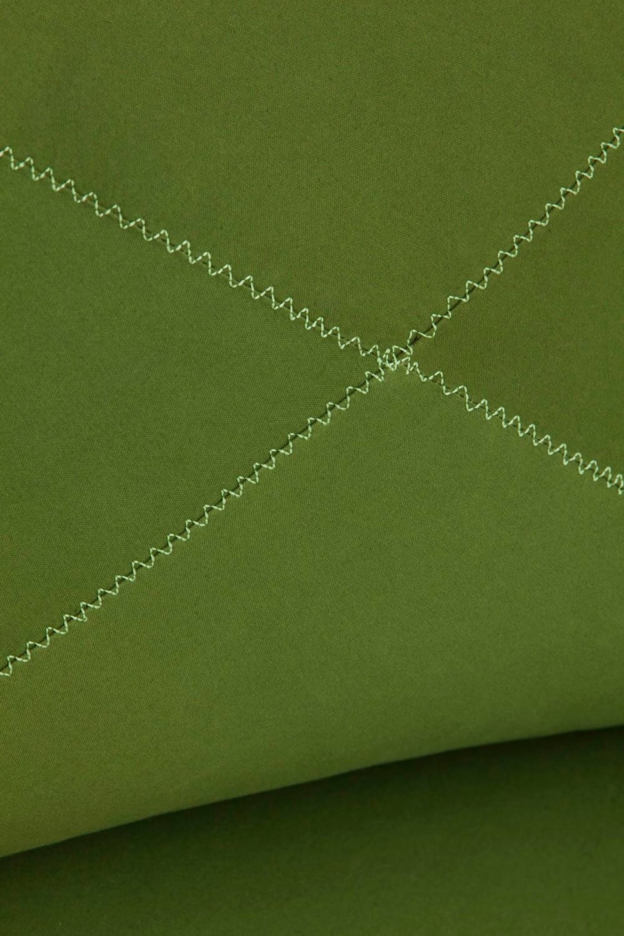Detailaufnahme des grünen Grapy Sitzkissens aus Baumwolle mit Zickzack-Steppung. Gemütliches Kissen für Wohnzimmer und mehr.