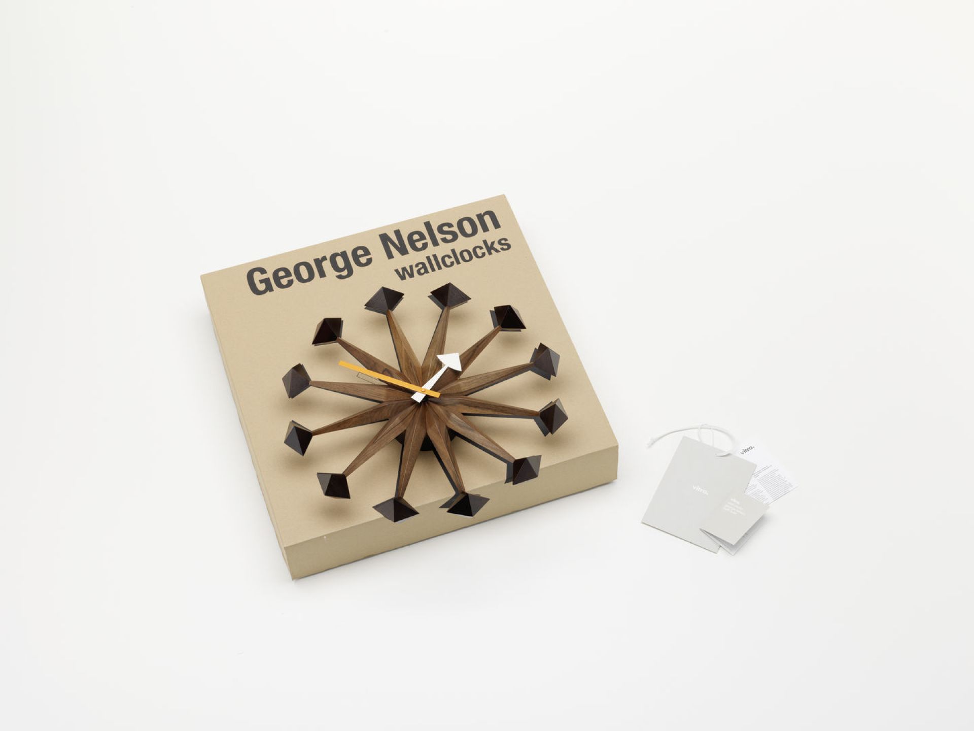 Vitra Polygon Clock Wanduhr auf Karton, moderne Design Wanduhr mit geometrischen Formen.