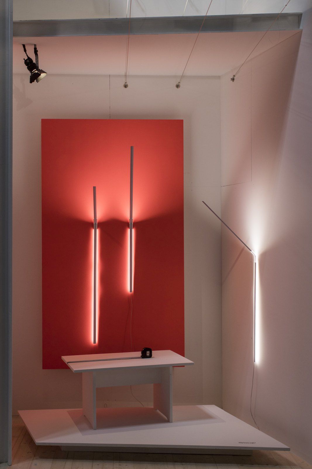 Ingo Maurer Measure Light Wandleuchten, minimalistisches Design mit linearen Lichtelementen in weißem Ausstellungsraum, moderne Wandbeleuchtung.