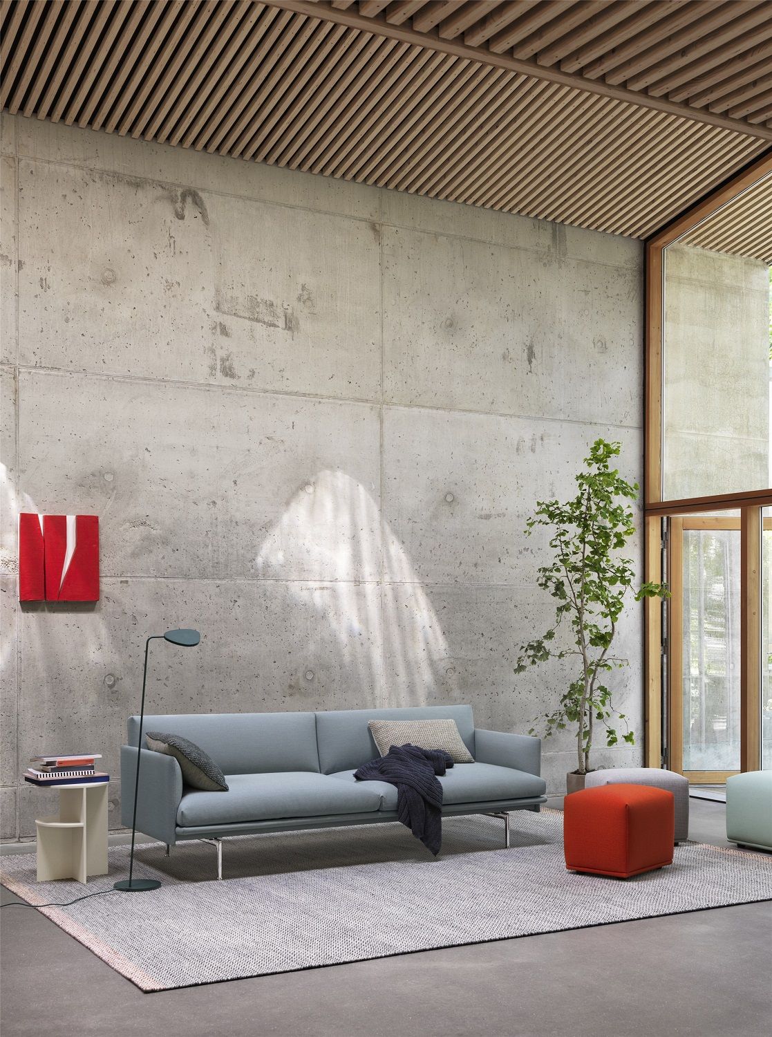 Wohnzimmer Interieur mit hellblauem Sofa, Stehlampe und farbigen Echo Pouf Hockern von Muuto.