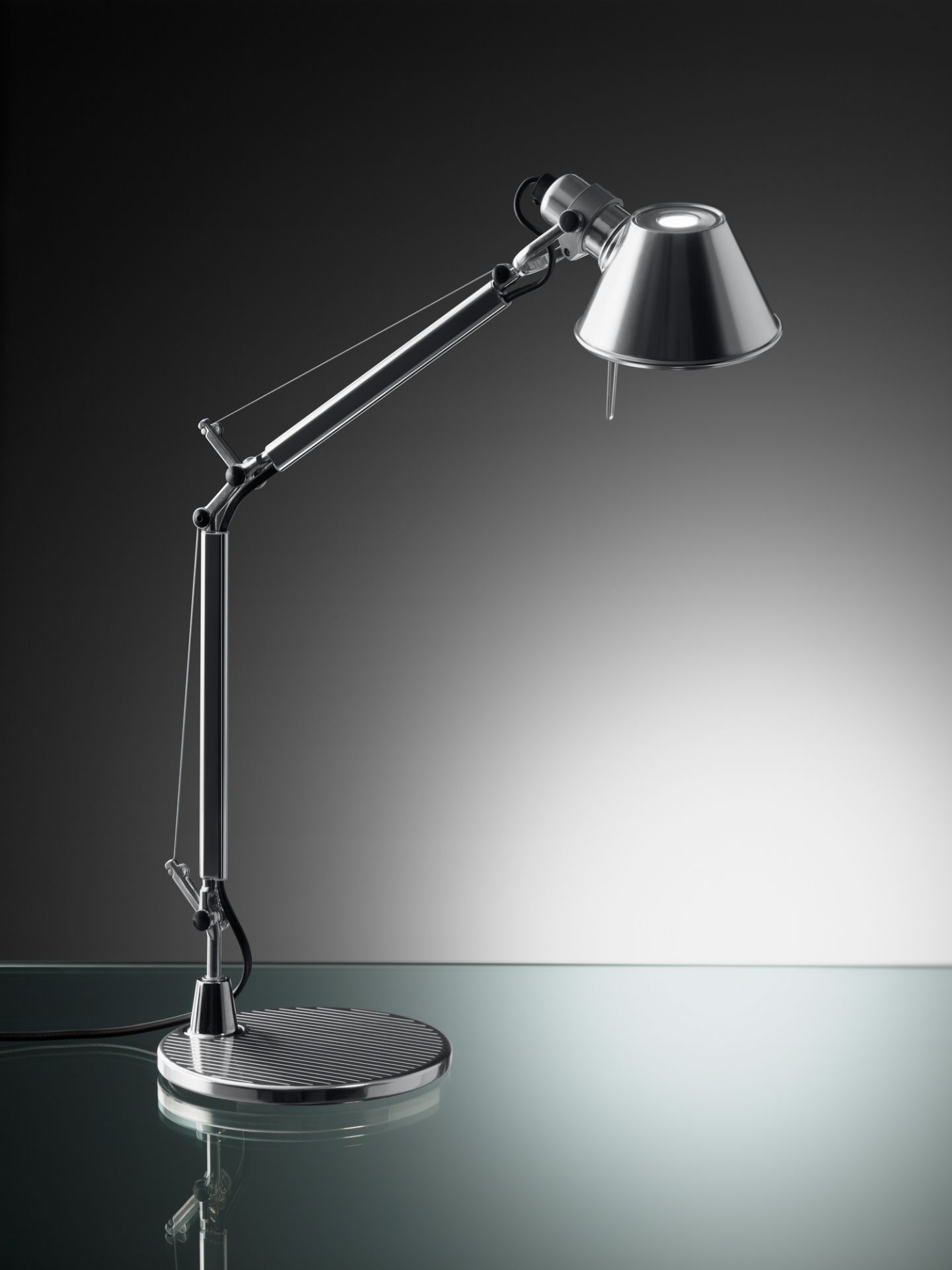 Nahaufnahme der modernen Artemide Tolomeo Micro Tischleuchte mit Fuß in poliertem Aluminium.