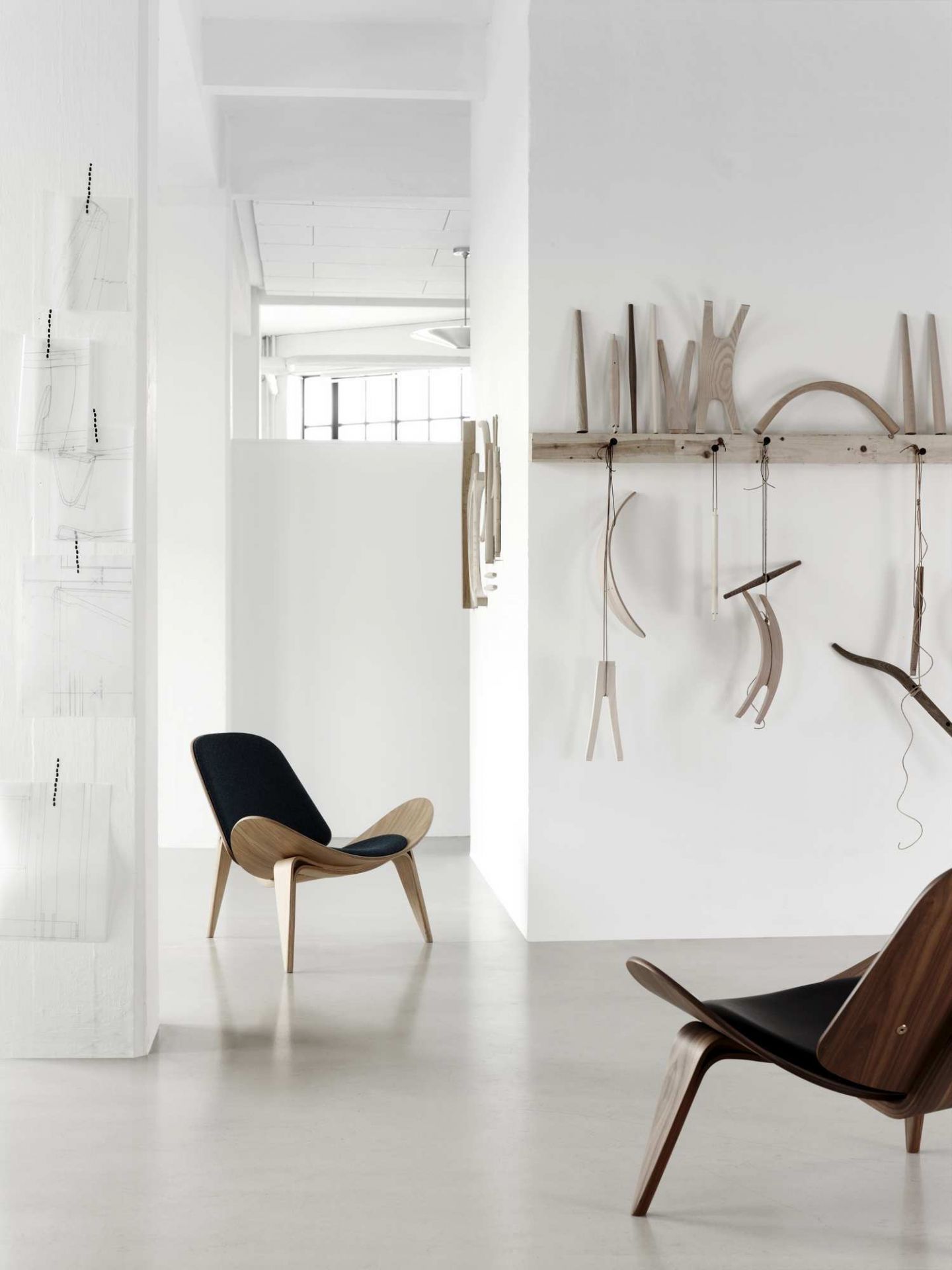 CH07 Shell Chair von Carl Hansen & Søn mit schwarzer Polsterung in hellem Raum.