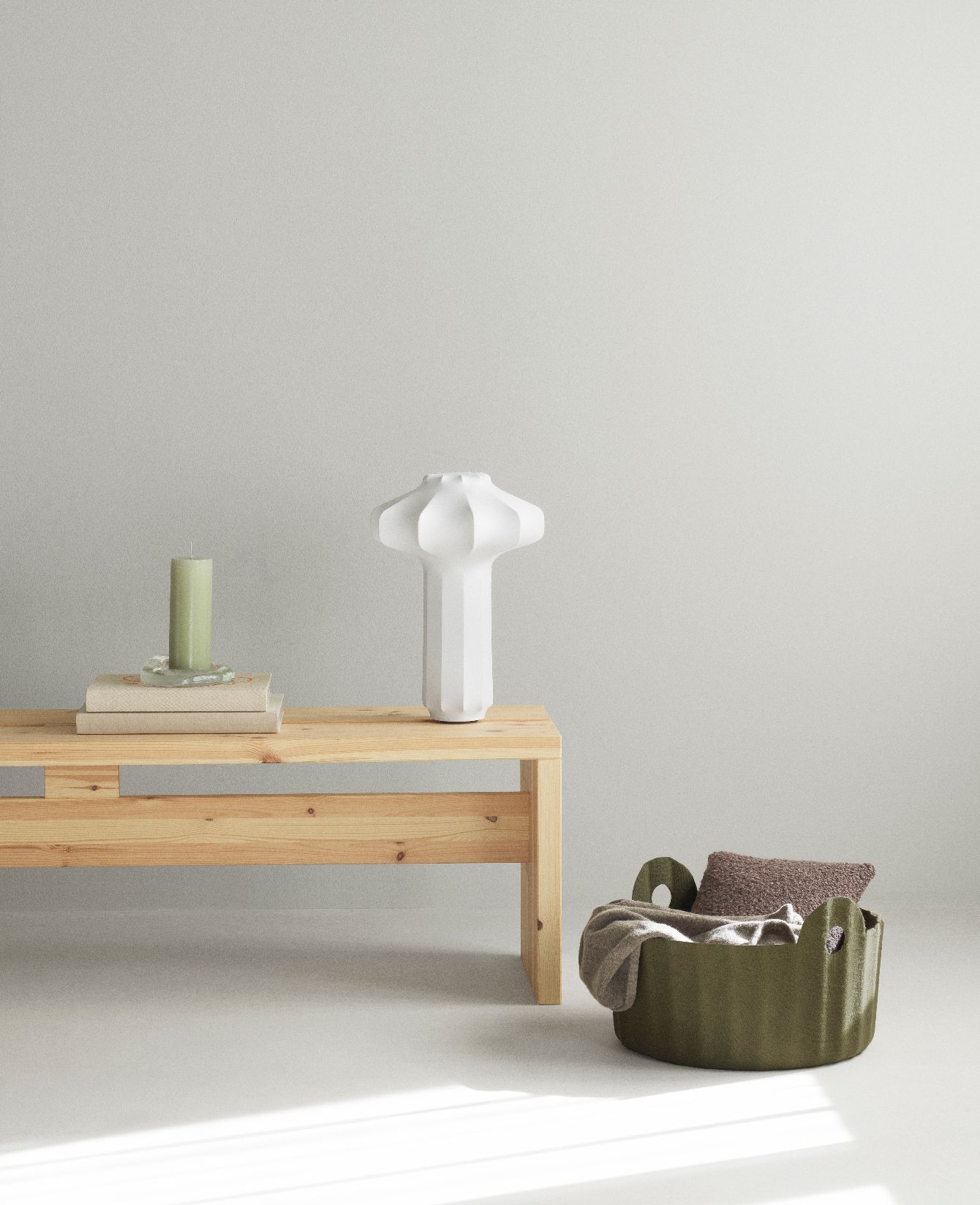 Weiße Phantom Tischleuchte von Normann Copenhagen auf einem Holztisch mit Kerze und Korb.