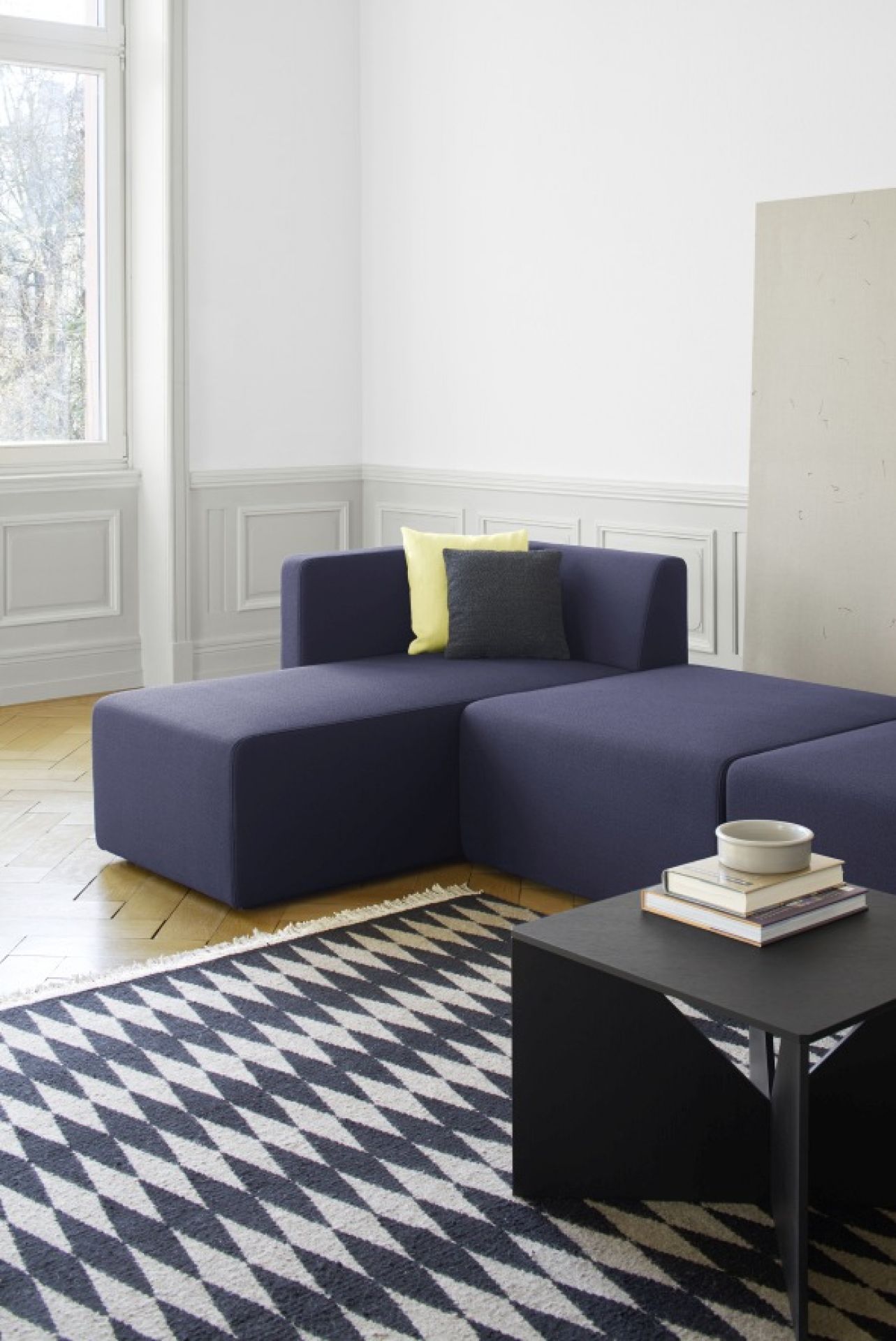SF06 Kerman Modulsofa von e15 in blau mit Kissen und Teppich im Wohnzimmer.