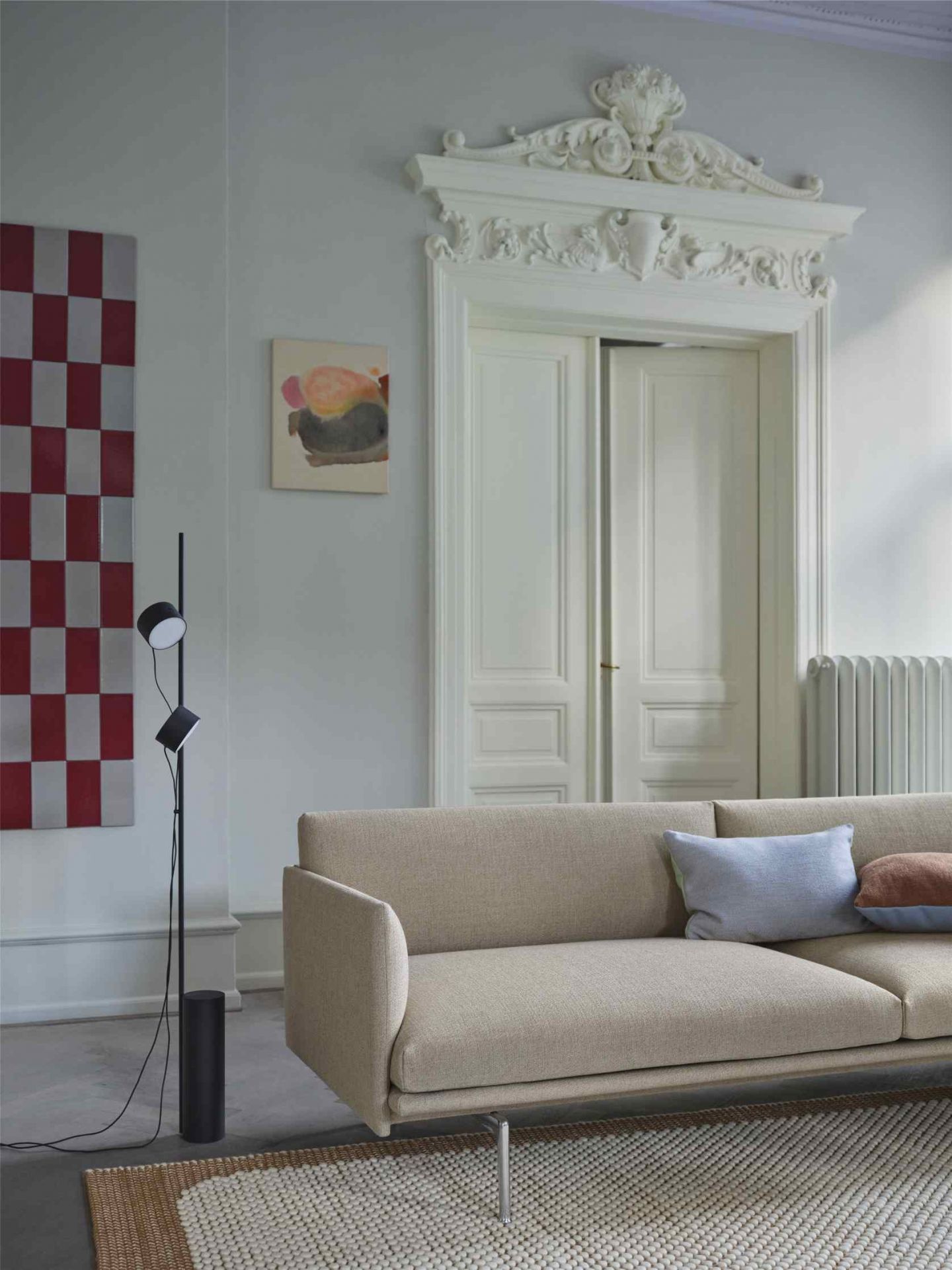 Beige Couch mit Muuto Kissen in Blau und Braun, modernes Wohnzimmer-Interieur.
