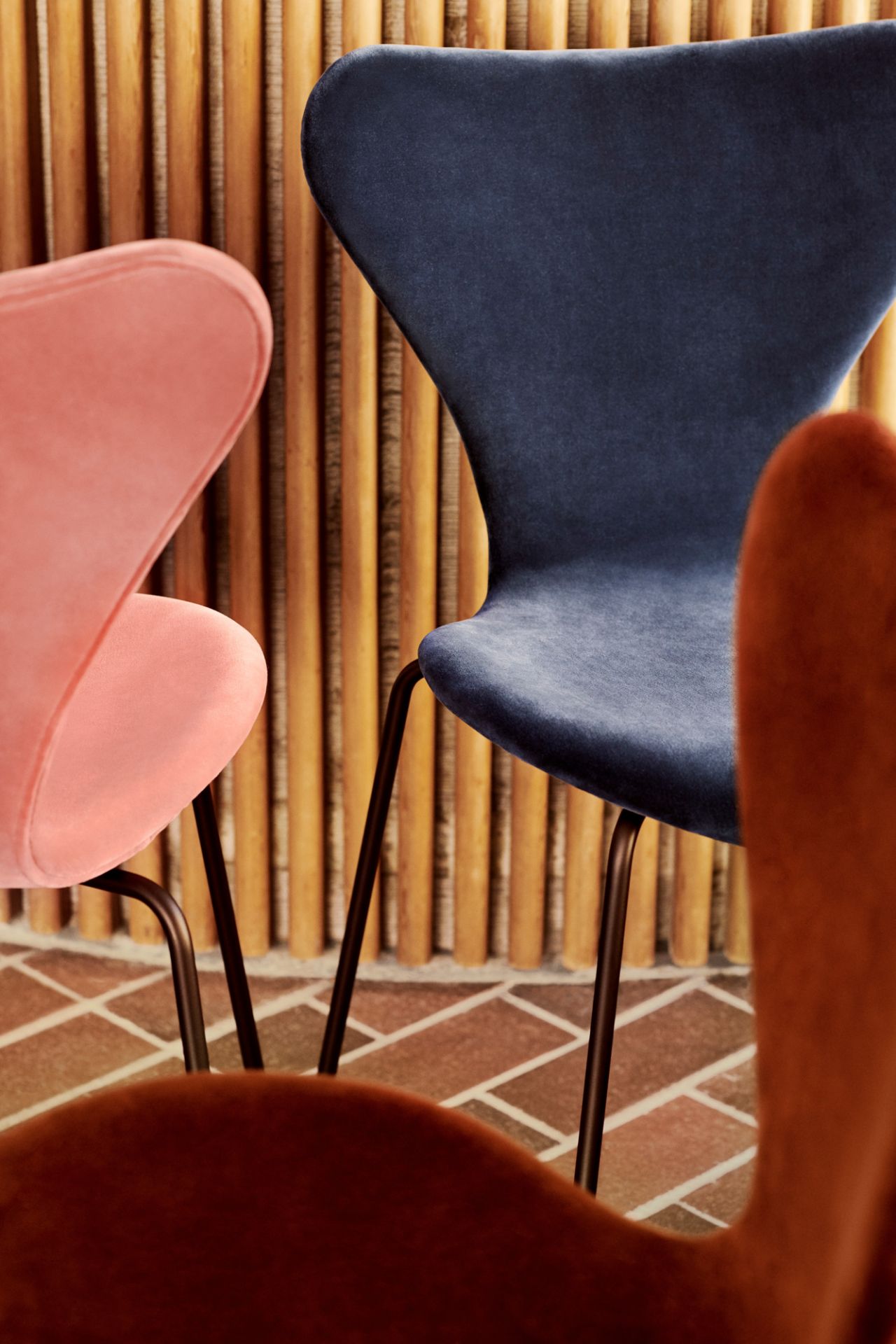 Nahaufnahme von drei Series 7 Stühlen mit Vollpolster in Samt, Fritz Hansen.