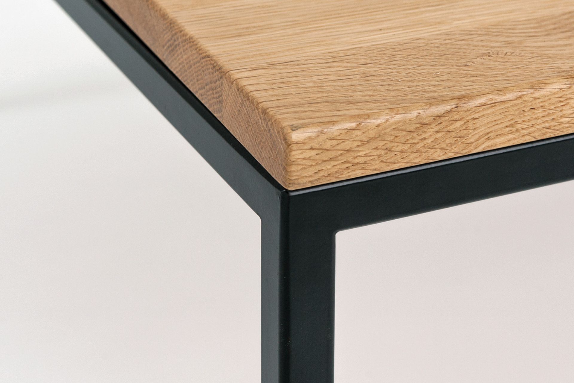 Detailaufnahme: Less H 5/2 Couchtisch Hans Hansen mit Eichenplatte und schwarzem Metallgestell.