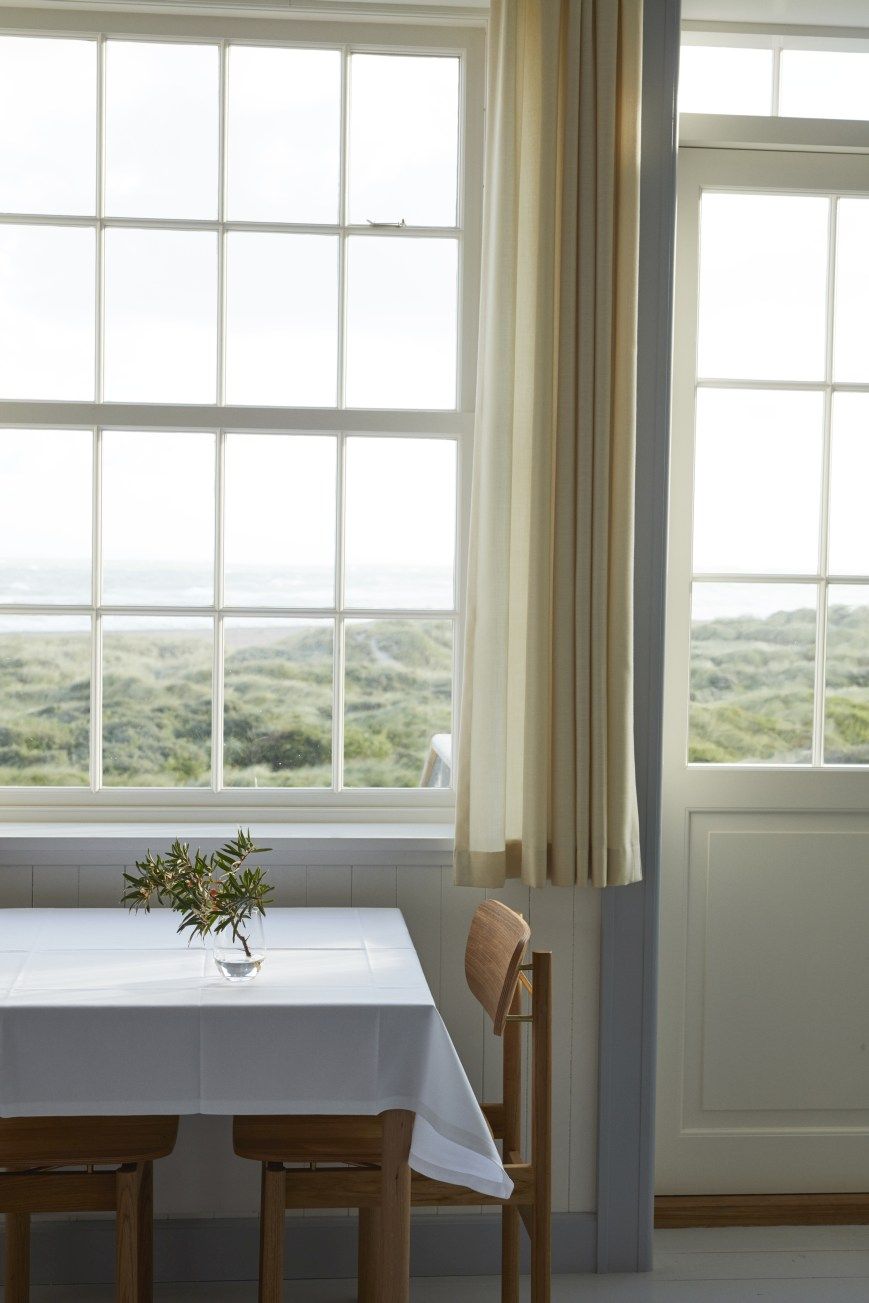 Vester Chair Stuhl von Skagerak by Fritz Hansen am Esstisch mit Meerblick.