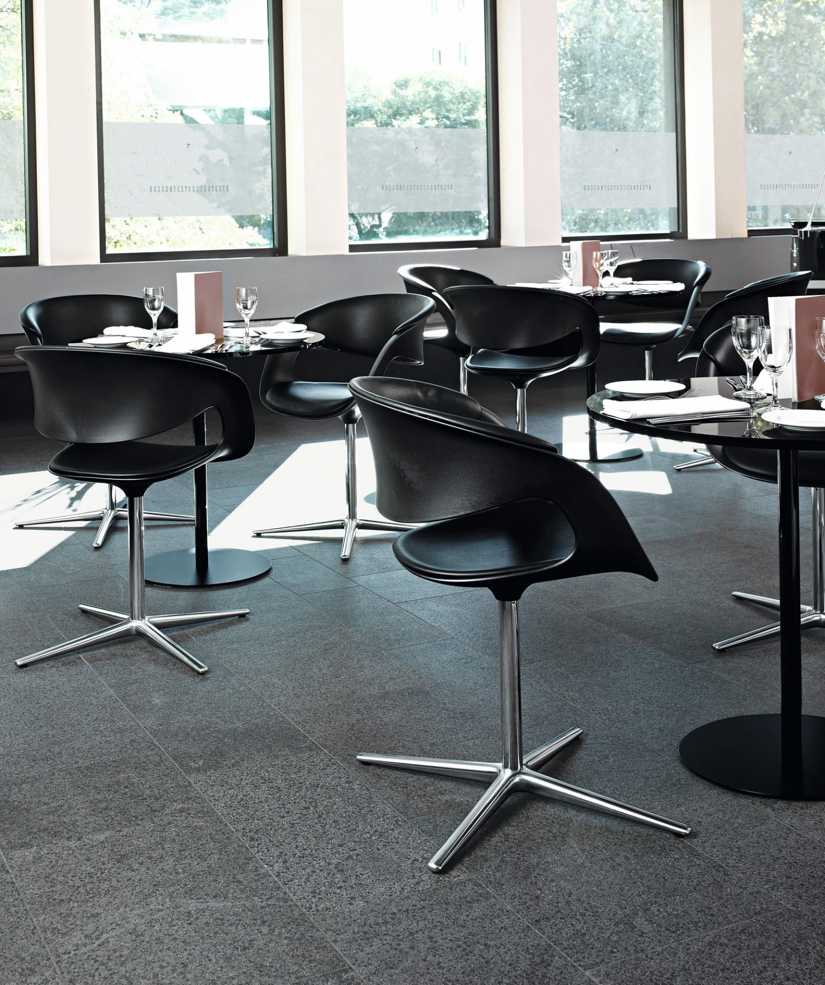 Schwarzer Lox Sessel von Walter Knoll in einem Restaurant, mit verchromtem Drehfuß und moderner Form.