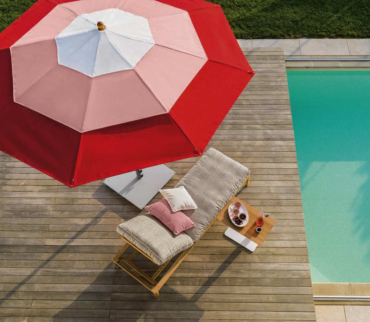 Weishäupl Klassiker Schirm in Rot-Weiß über einer Sonnenliege am Pool, ideal für entspannte Sommertage.