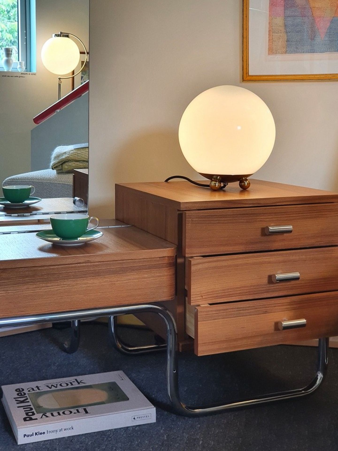 Art Déco Tischleuchte AD32 Tecnolumen mit runder, opalweißer Glaskugel auf Holzkommode. Design Lampe.
