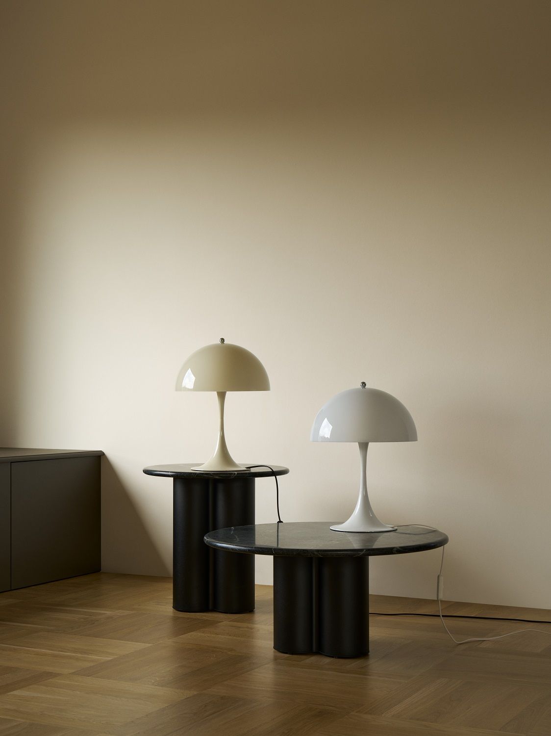 Zwei Panthella Tischleuchten in Opal Weiß auf schwarzen Tischen, modernes Design für Wohnzimmer und Schlafzimmer.