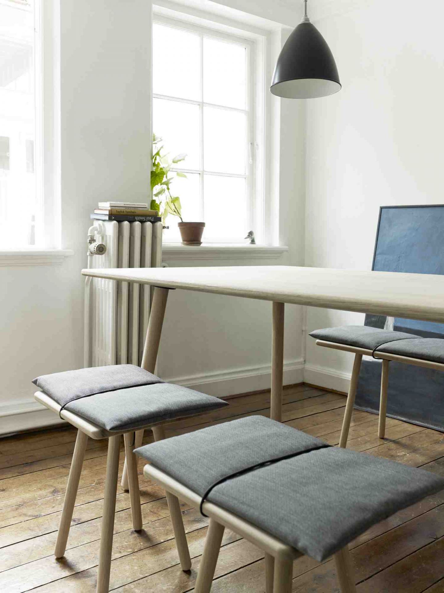 Georg Dining Table von Skagerak: Heller Holztisch mit grauen Hockern in einem hellen Raum.