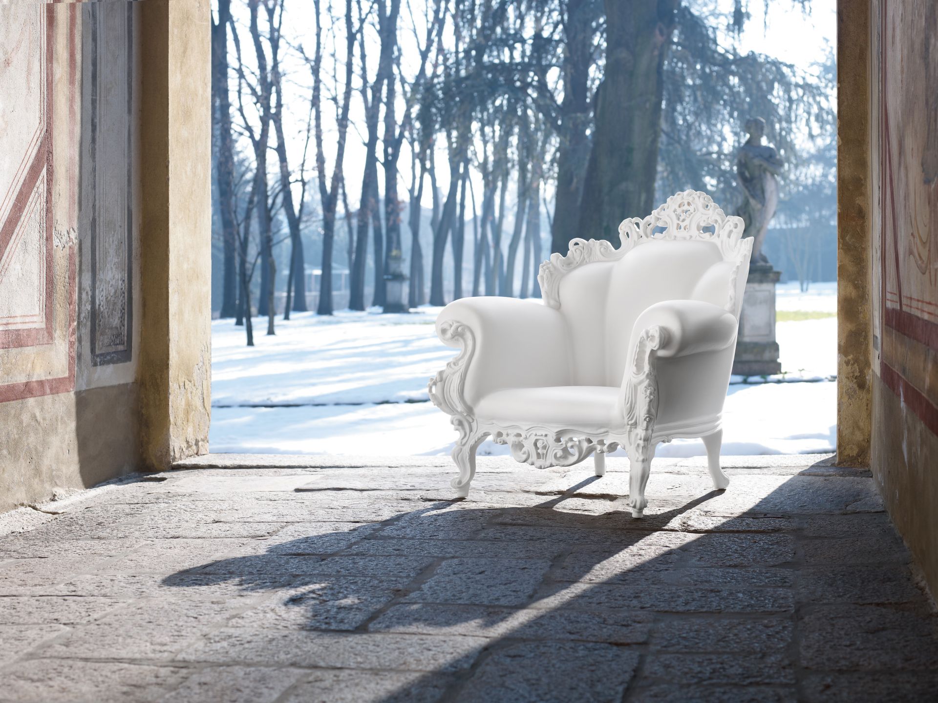 Weißer Proust Sessel Outdoor von Magis mit filigranem Design vor winterlicher Parklandschaft.