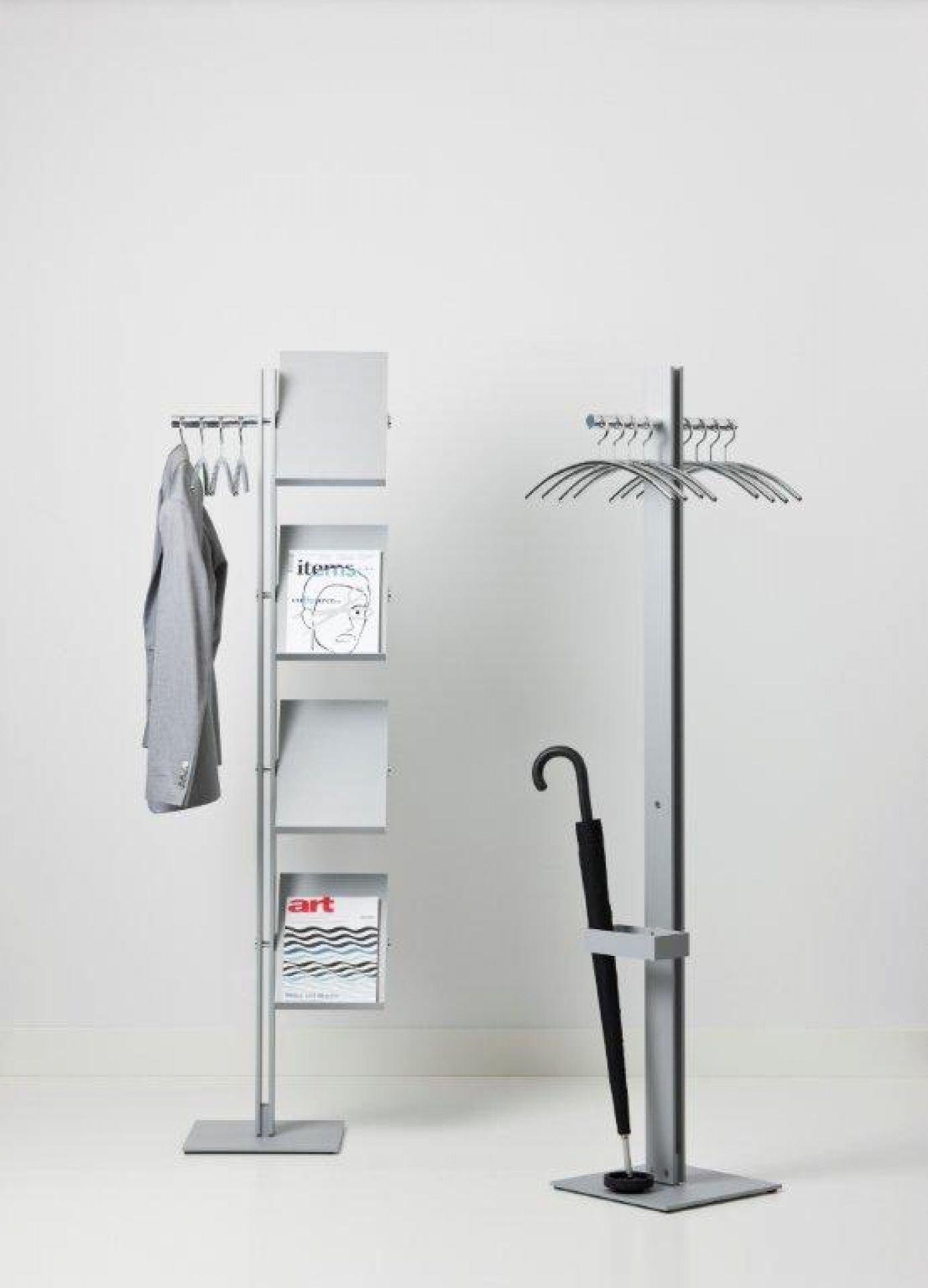 Standfree B Garderobenständer von Cascando mit Prospektablagen, Mantel, Regenschirm und Zeitschriften in grau.