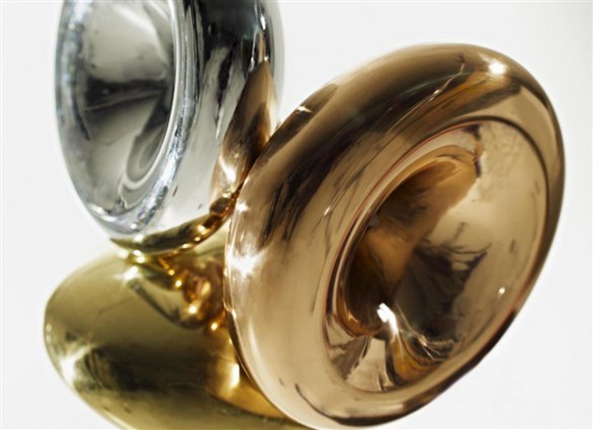 Dekorative Skulptur mit drei metallischen Röhren in Gold, Silber und Bronze für moderne Inneneinrichtung.