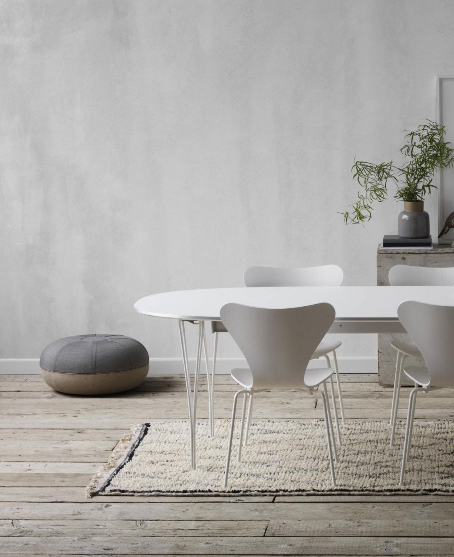 Weißer Super Elliptisch Ausziehtisch von Fritz Hansen mit Stühlen und Teppich auf Holzboden.