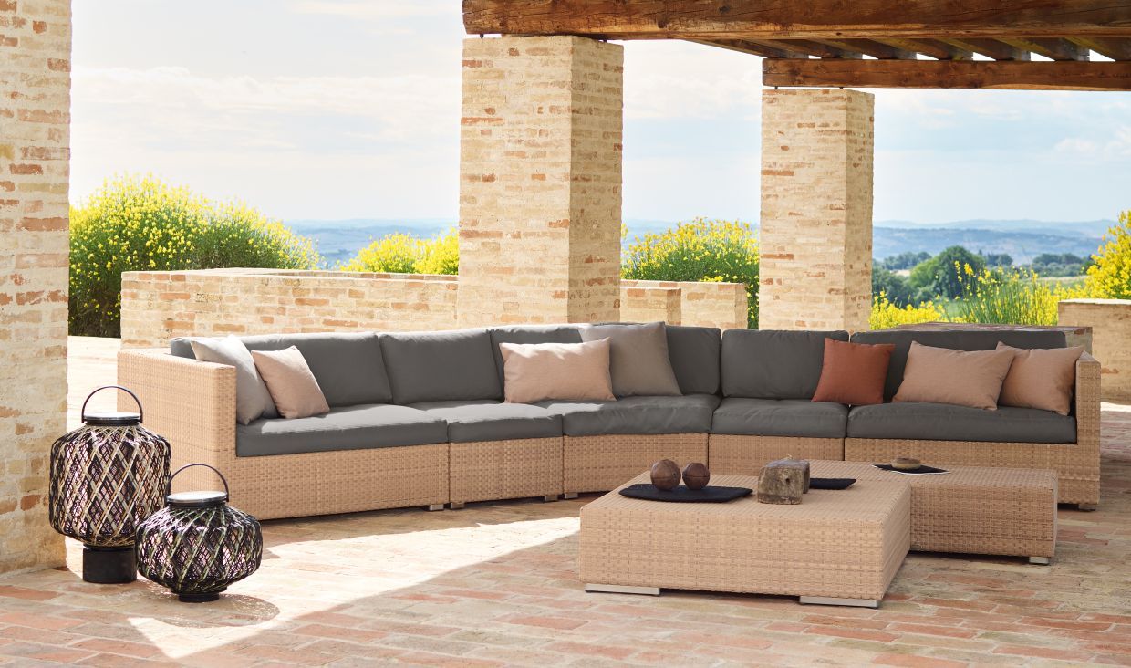 Dedon Lounge Sonnenliege mit Polstern auf einer Terrasse mit Blick auf die Landschaft.