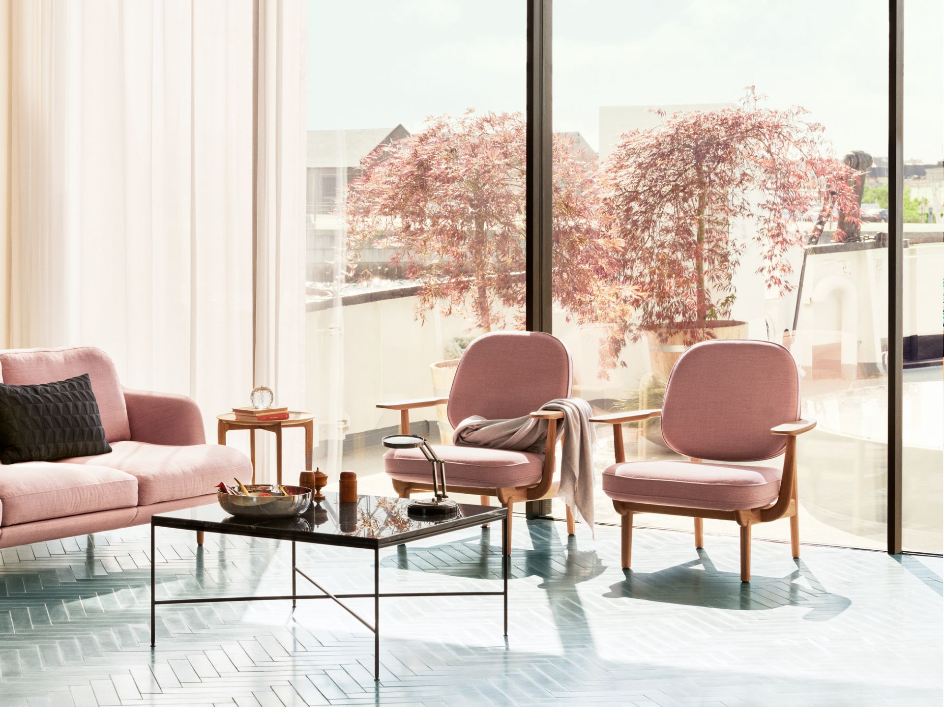 Wohnzimmer mit Fred Loungesessel von Fritz Hansen, Eiche klar lackiert, rosa Sofa und Couchtisch.