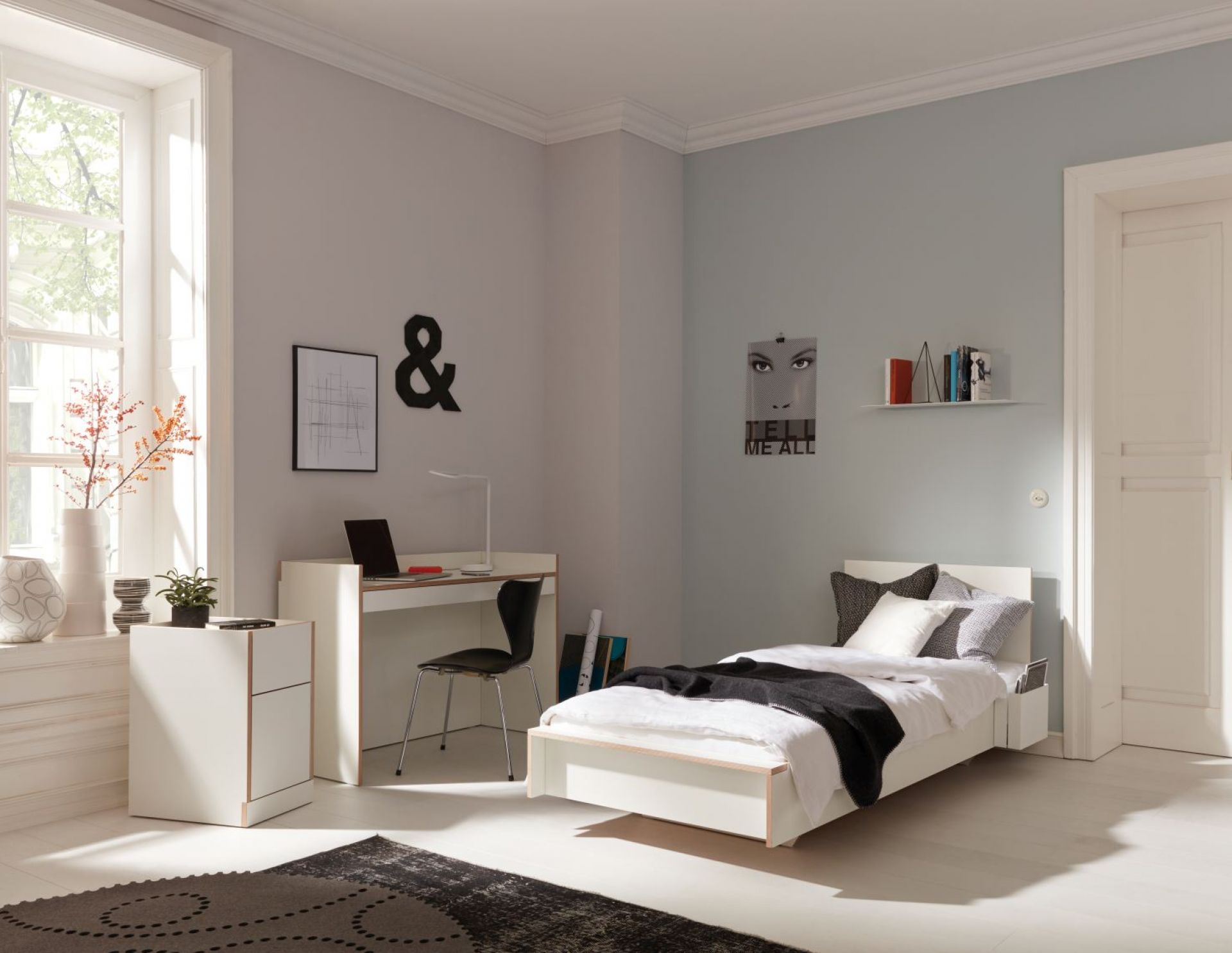 Helles Schlafzimmer mit weißem Flai Bett von Müller Möbelwerkstätten, Schreibtisch und Nachttisch.