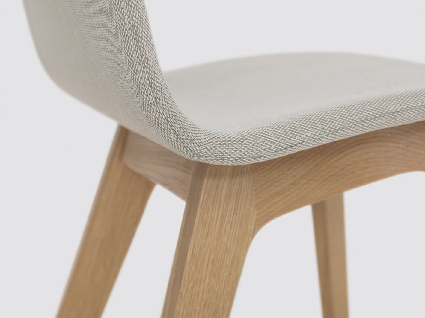 Detailaufnahme: Morph Stuhl mit Holzgestell und hellgrauer Vollpolsterung, modernes Design.