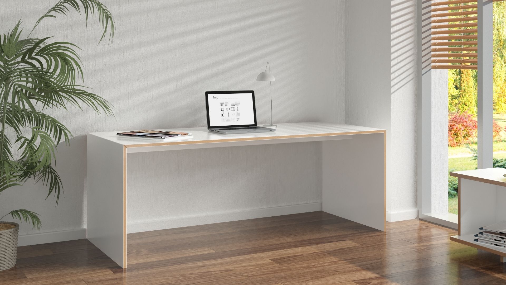 Weißer Tojo Schreibtisch groß mit Laptop und Lampe im hellen Arbeitszimmer. Moderner Bürotisch.