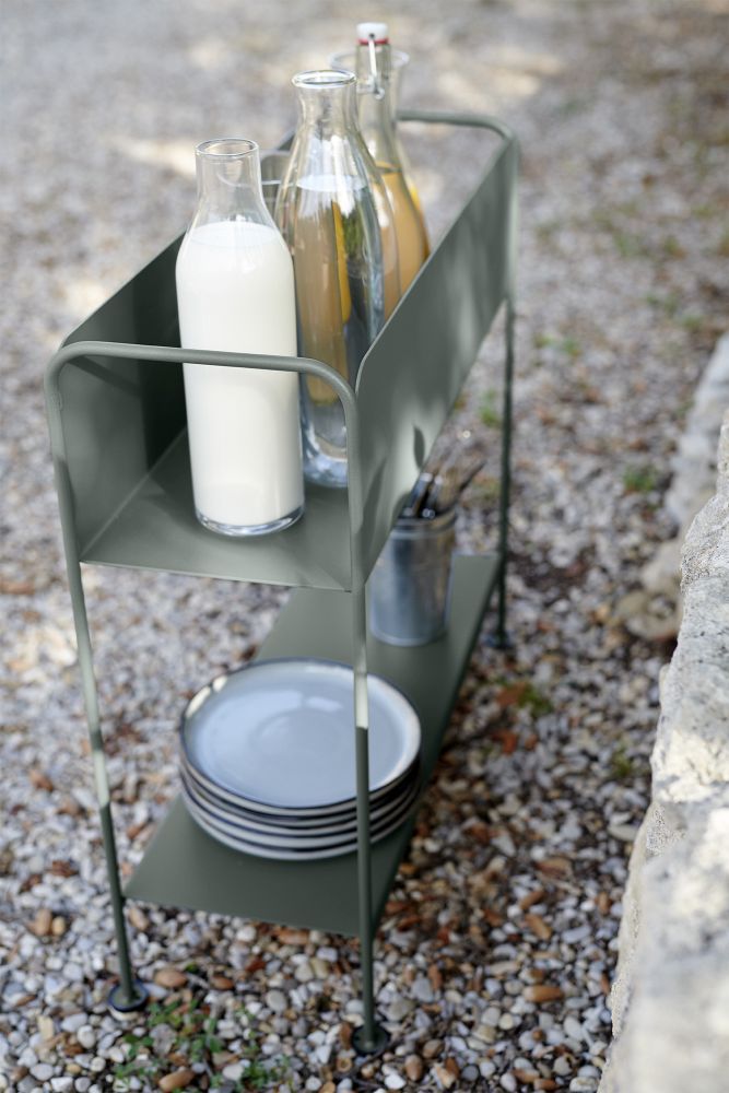 Picolino Servierwagen von Fermob in Moosgrau mit Getränken und Geschirr im Garten.