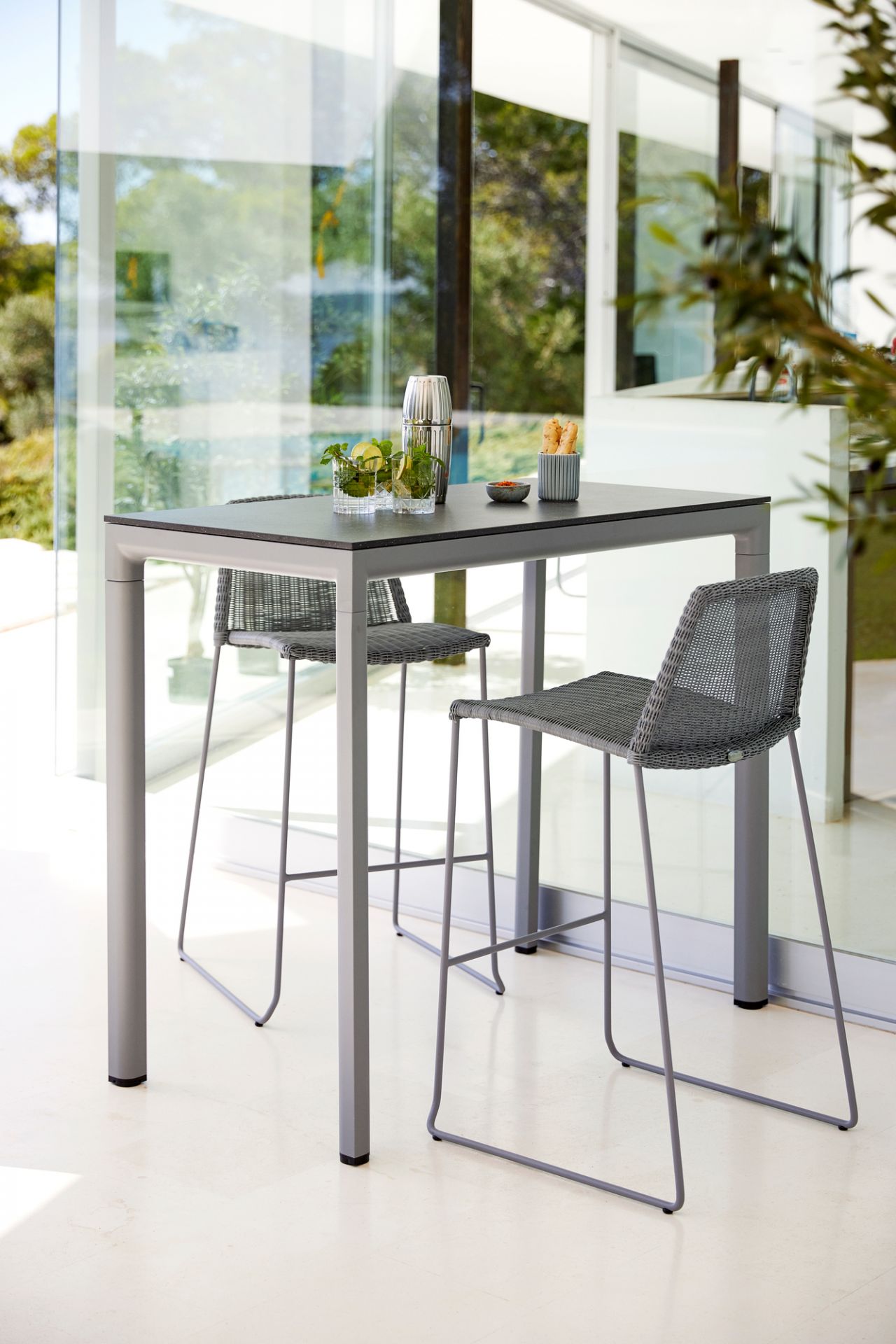 Zwei graue Cane-Line Breeze Barhocker mit Tisch für den Aussenbereich. Outdoor Möbel.