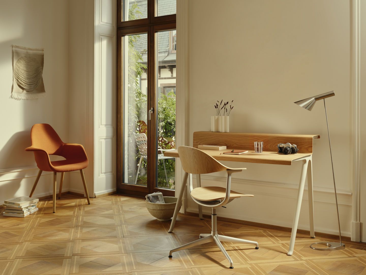 Vitra Courier Schreibtisch aus hellem Holz mit weißem Gestell in einem stilvollen Arbeitszimmer.