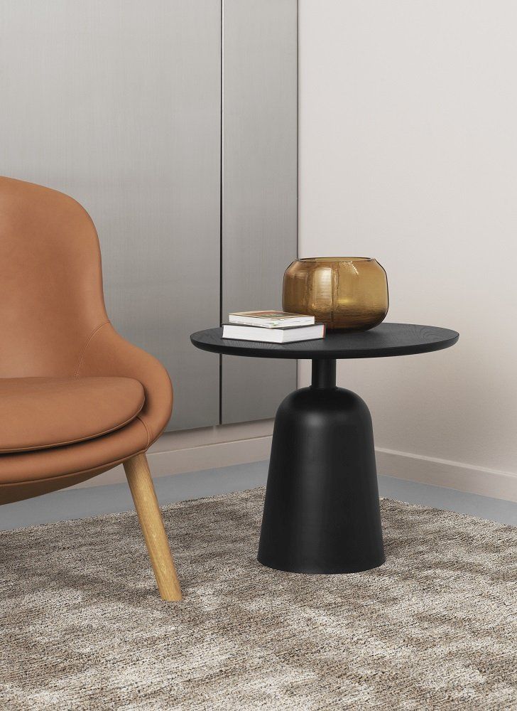 Detailaufnahme: Normann Copenhagen Hyg Lounge Chair Sessel in Leder neben einem schwarzen Beistelltisch.