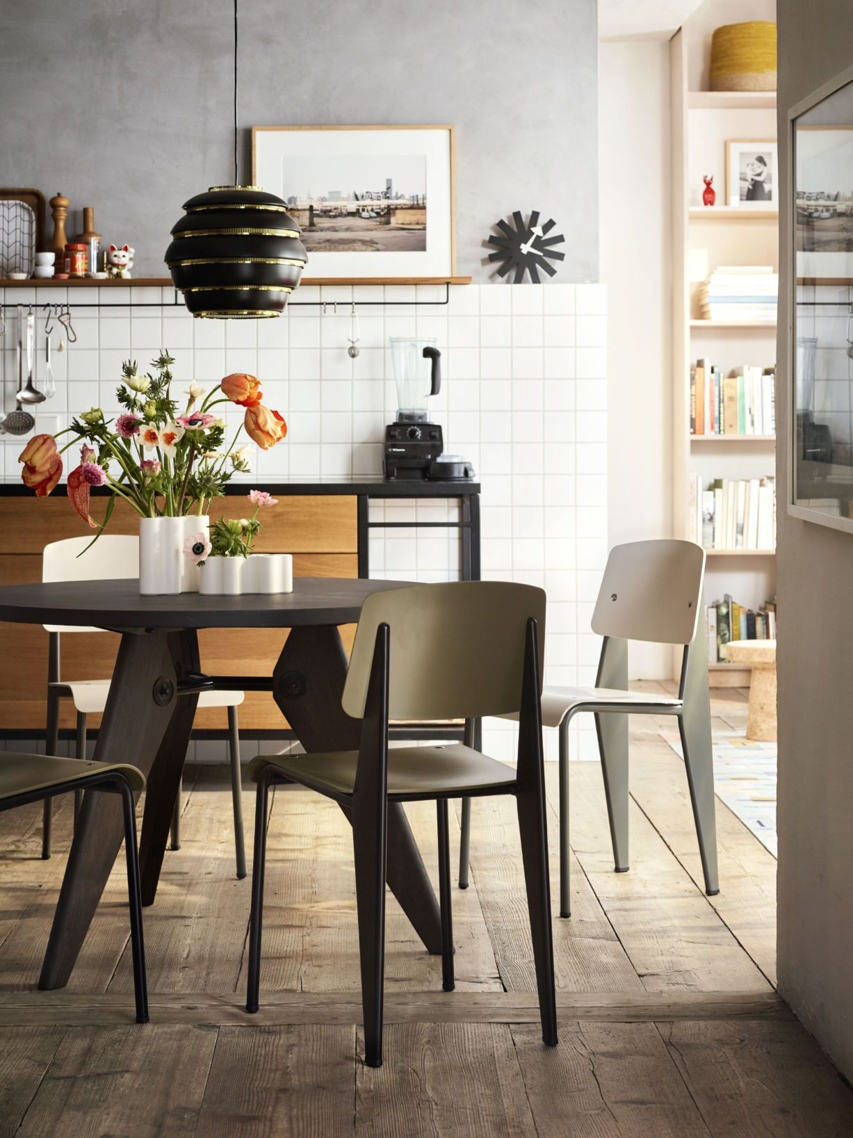 Esszimmer mit Vitra Asterisk Clock Wanduhr, modernem Tisch und Stühlen im minimalistischen Design.