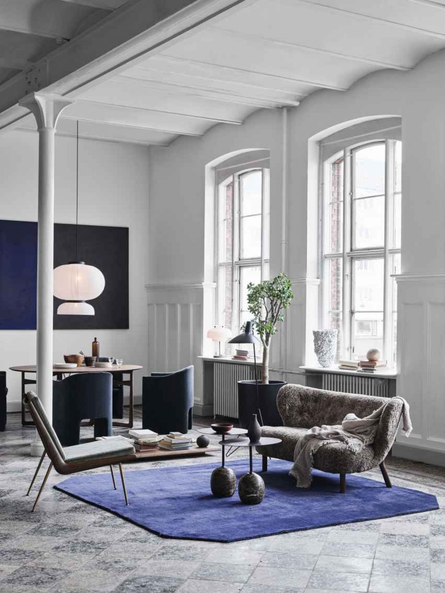 AndTradition The Moor Rug Teppich in einem stilvollen Wohnzimmer mit Möbeln und Dekoration.
