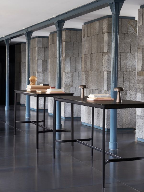 Zwei AndTradition Drip Stehtische aus schwarzem Metall in einem modernen Raum mit Büchern.