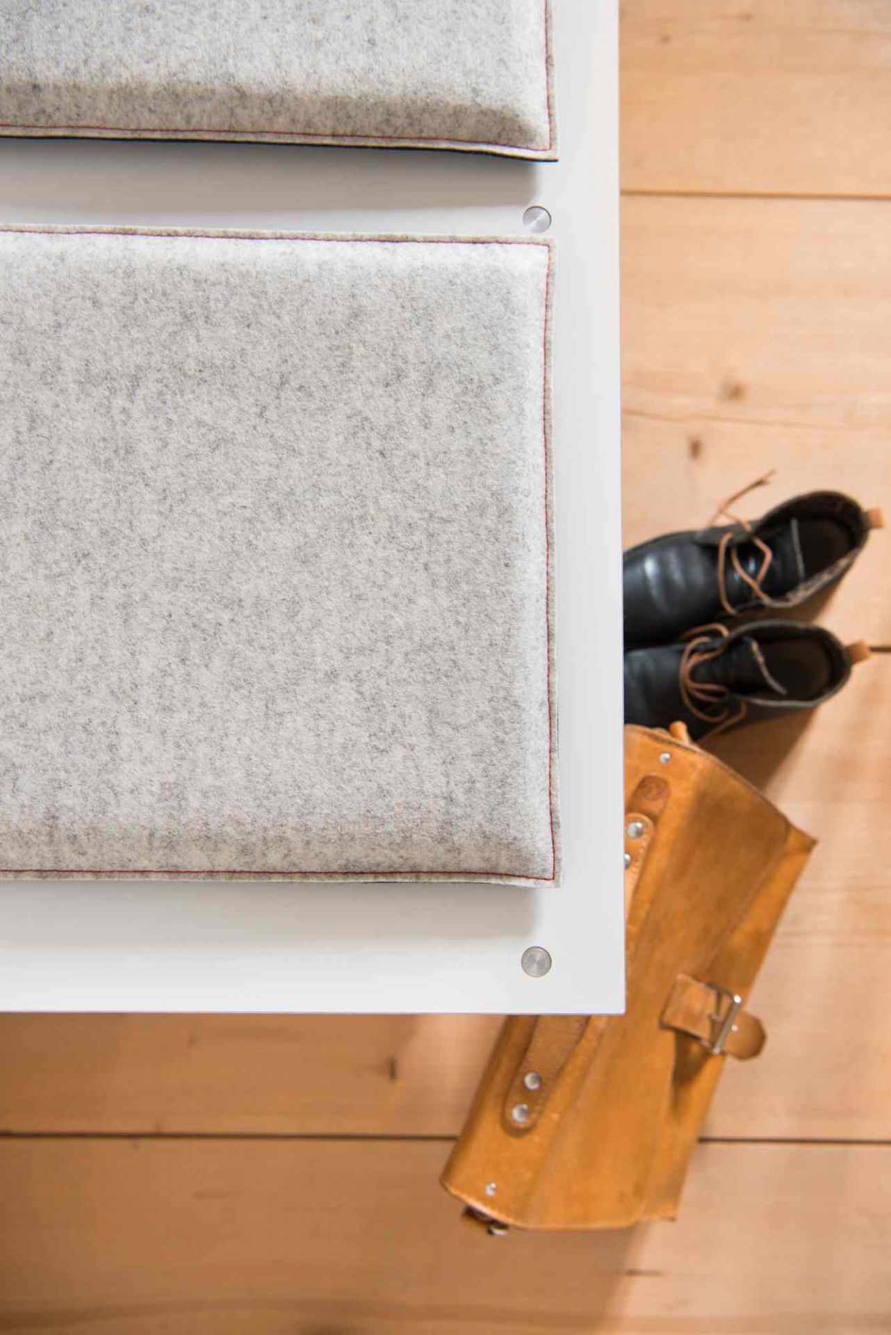 Detailaufnahme: Setzen 6 Sitzkissen von Moormann, grauer Filz mit roter Naht, weiße Halterung.