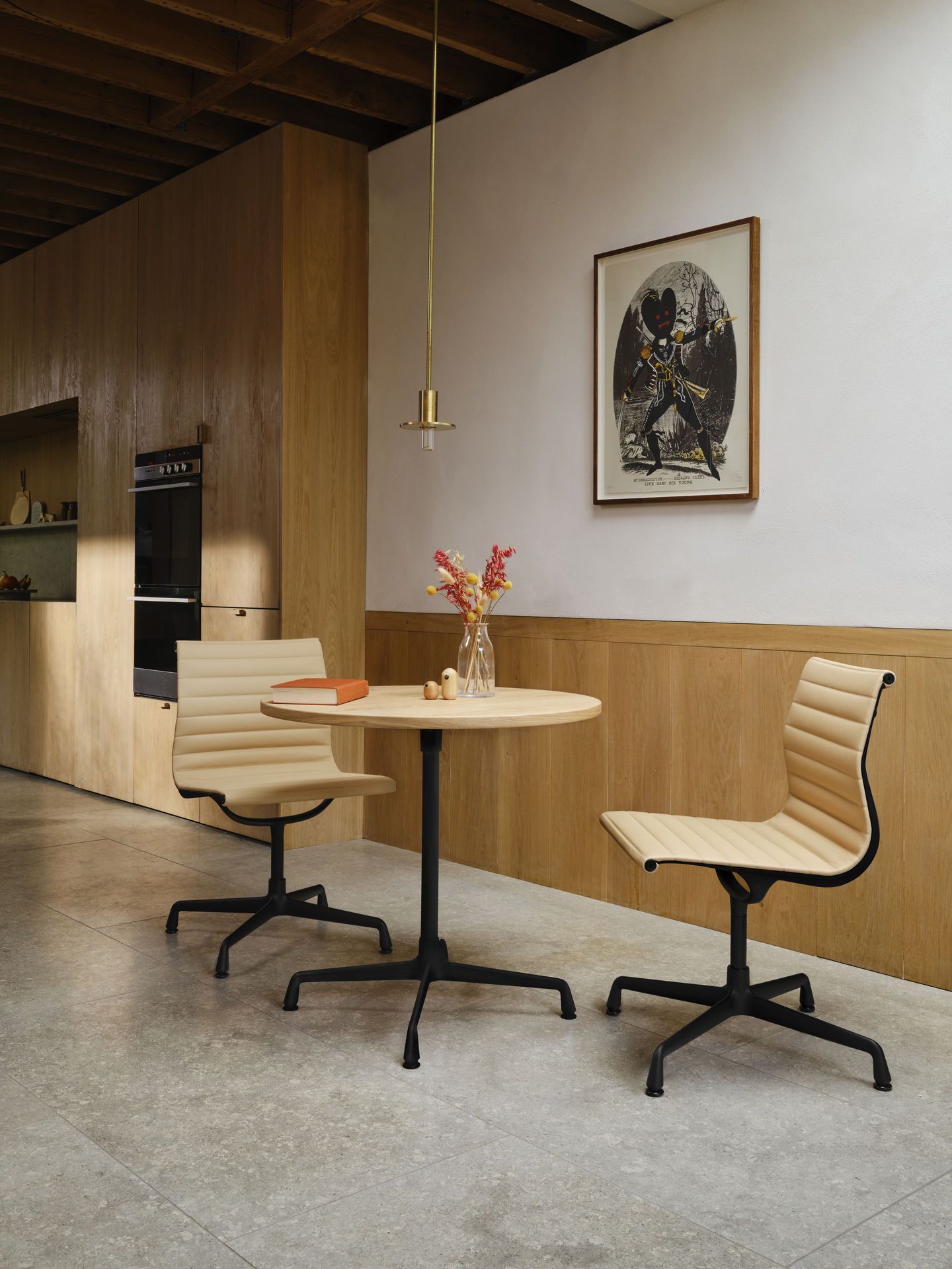 Zwei Vitra EA 101 Aluminium Stühle in Beige um einen runden Holztisch in modernem Interieur.