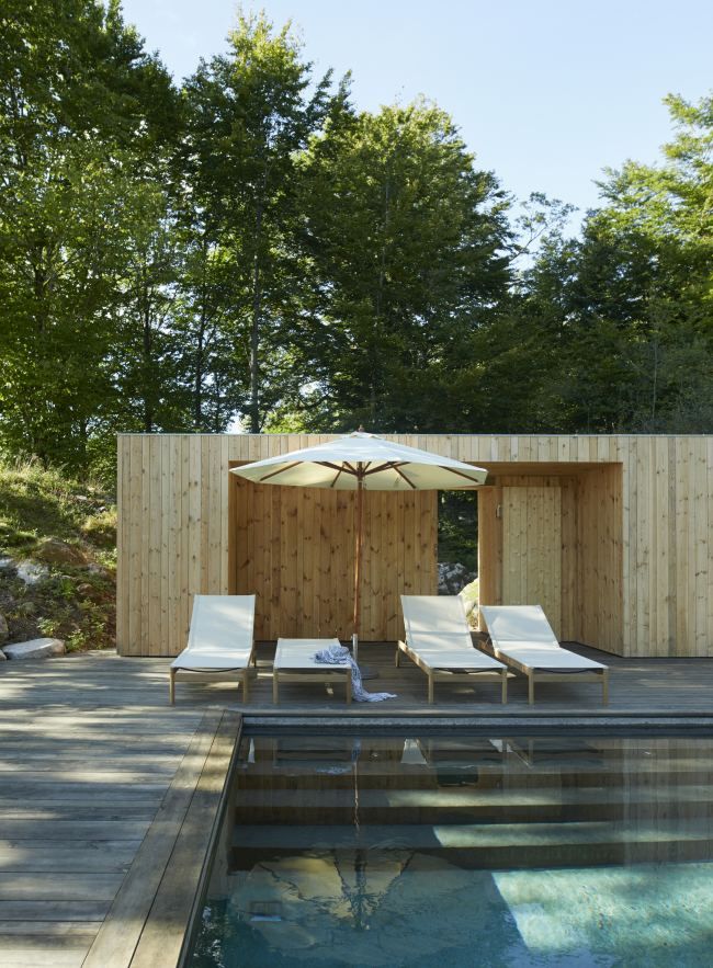 Pelagus Sonnenliegen von Skagerak by Fritz Hansen am Pool mit Sonnenschirm und Holzterrasse im Garten.