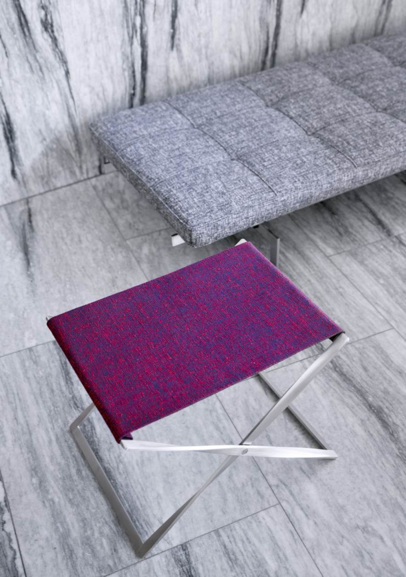 Nahaufnahme des PK91 Falthockers von Fritz Hansen mit purpurrotem Stoffbezug und silbernem Gestell.