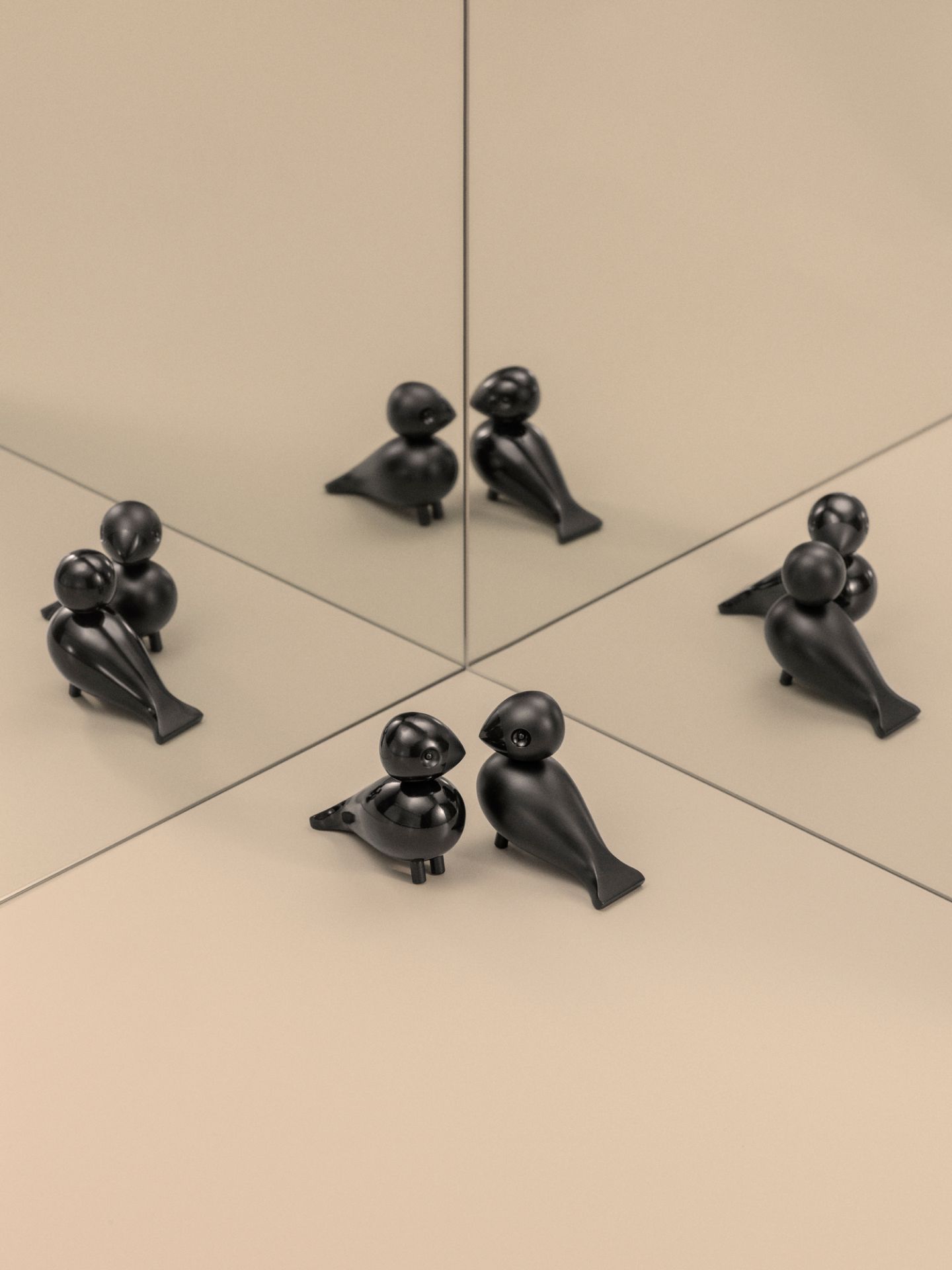 Kay Bojesen Unzertrennliche Lovebirds, schwarze Holzfiguren, dekorative Designobjekte, reflektiert in Spiegelflächen, skandinavisches Design.