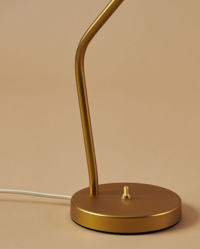 Detailaufnahme der goldenen Gräshoppa Tischleuchte von Gubi, Fokus auf Fuß und Schalter. Design-Klassiker für Schreibtisch und Büro.