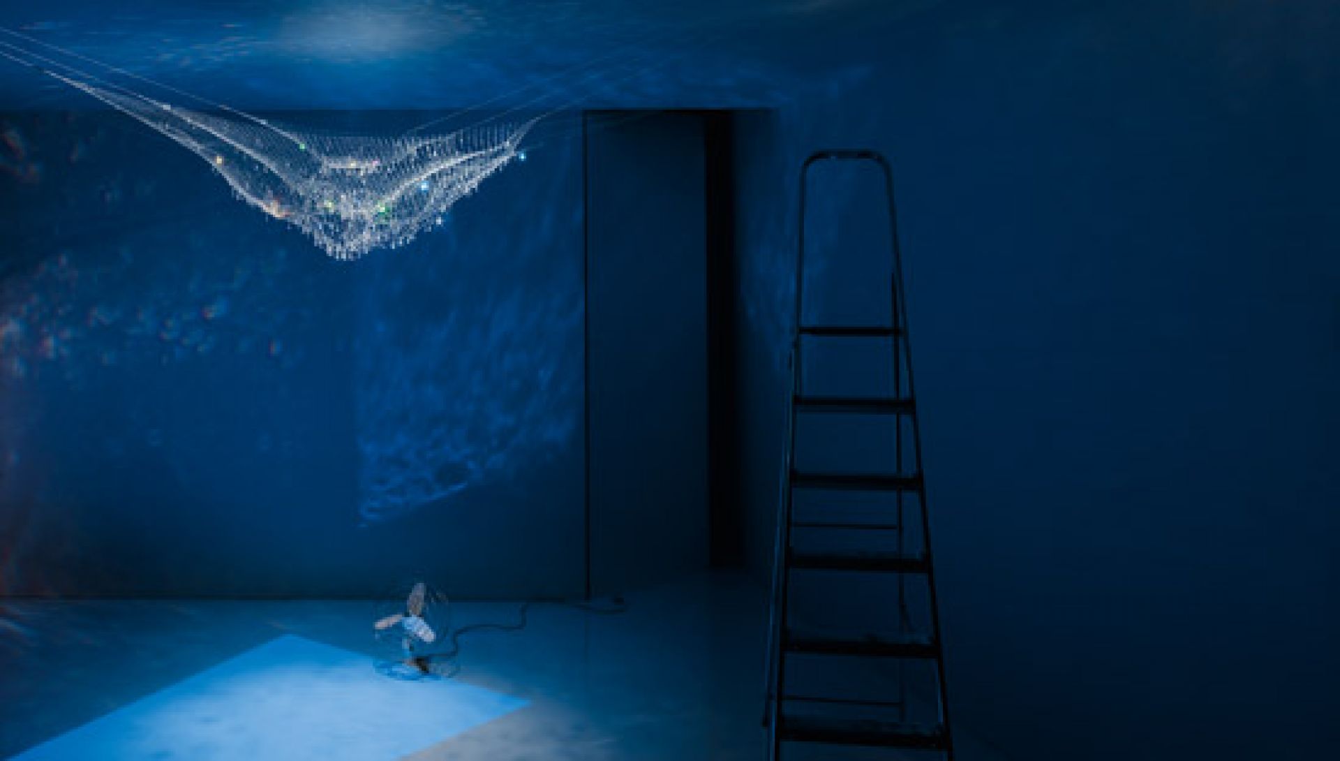 LACRIME DEL PESCATORE Pendelleuchte von Ingo Maurer, hängend im Raum, blaues Licht.