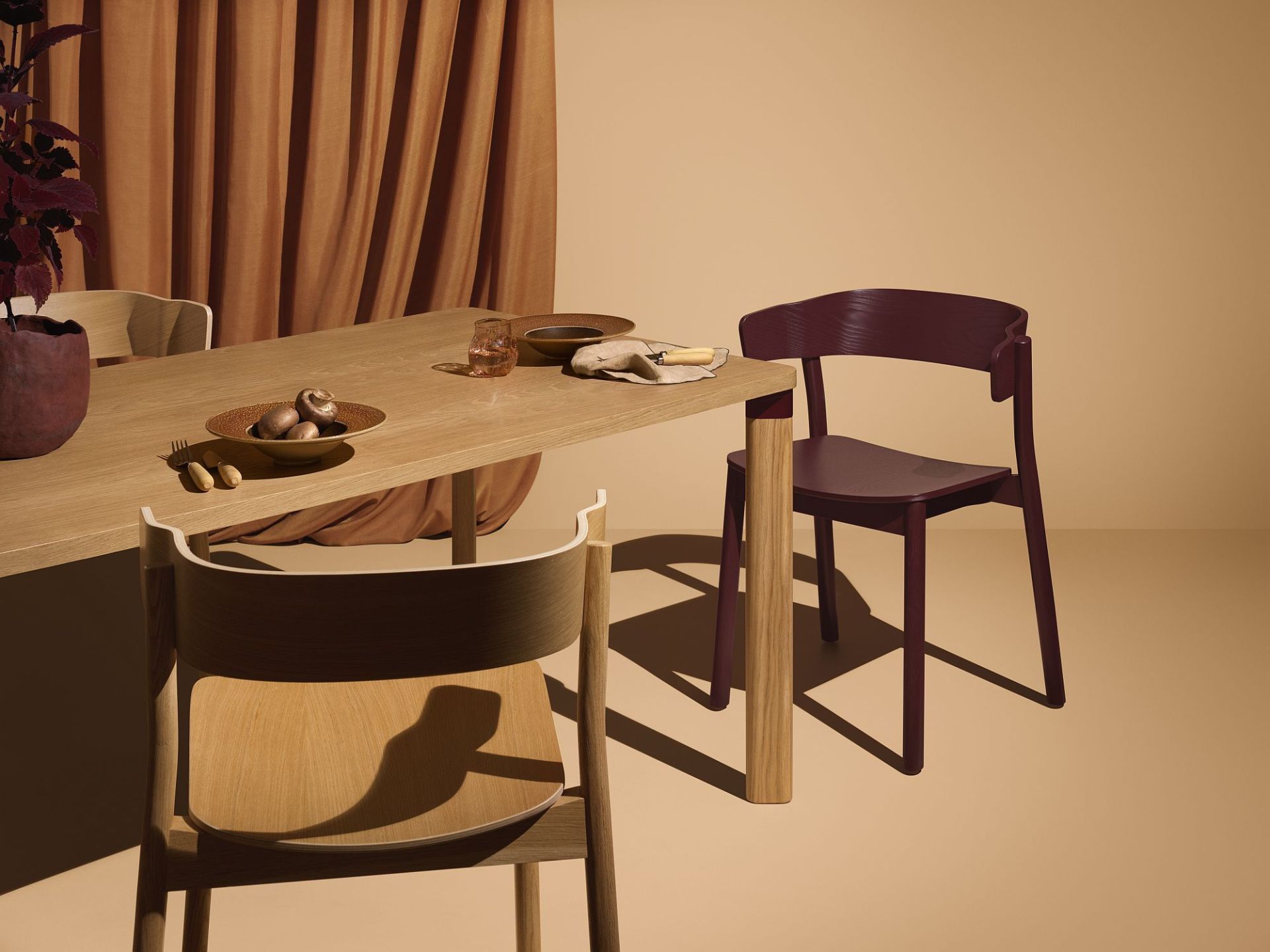 Enfold Table von Mizetto, ein Esstisch aus Holz mit Stühlen in gedeckten Farben.